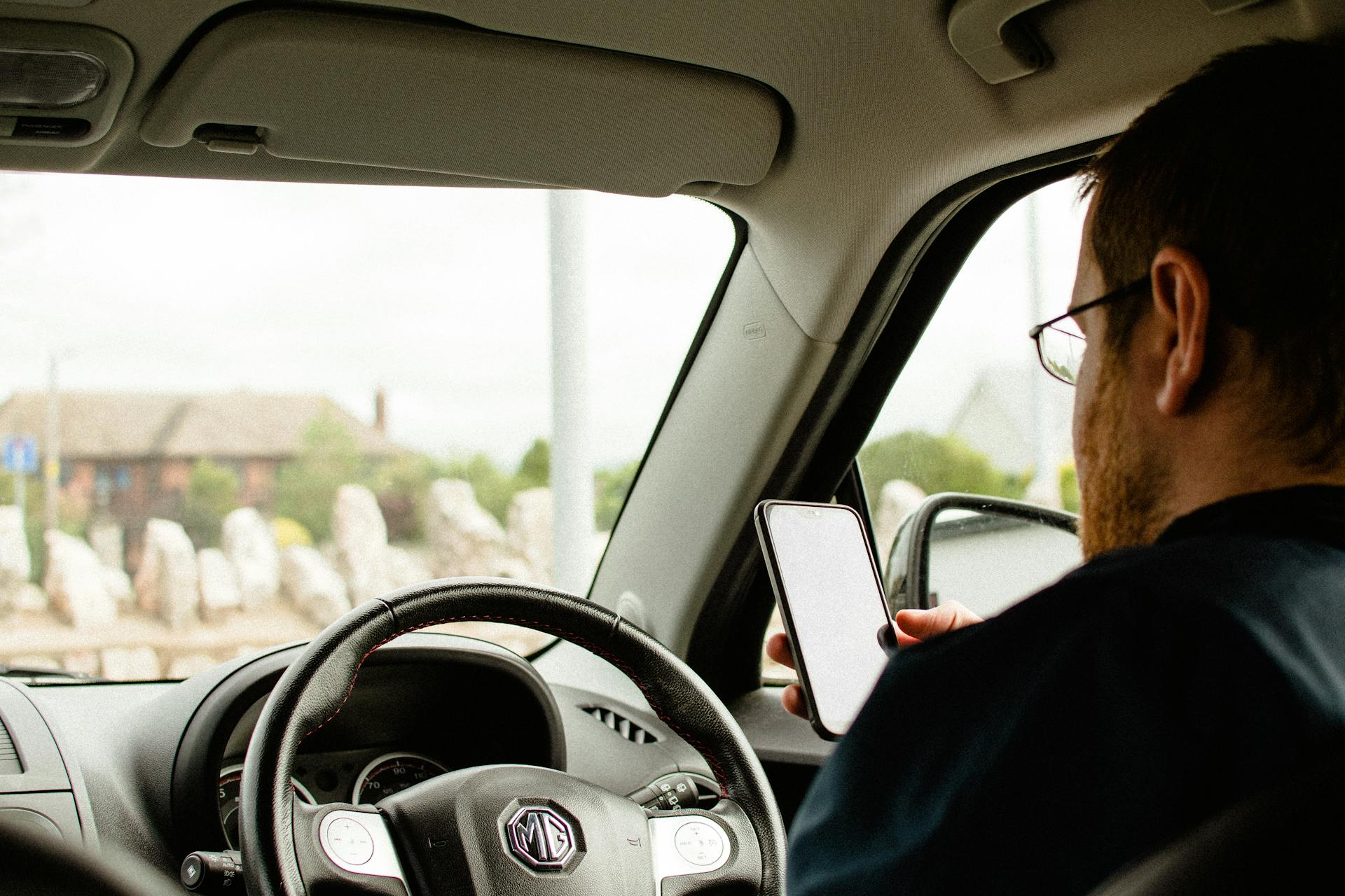 Ein Mann in einem Auto, der sein Telefon hält | Quelle: Pexels