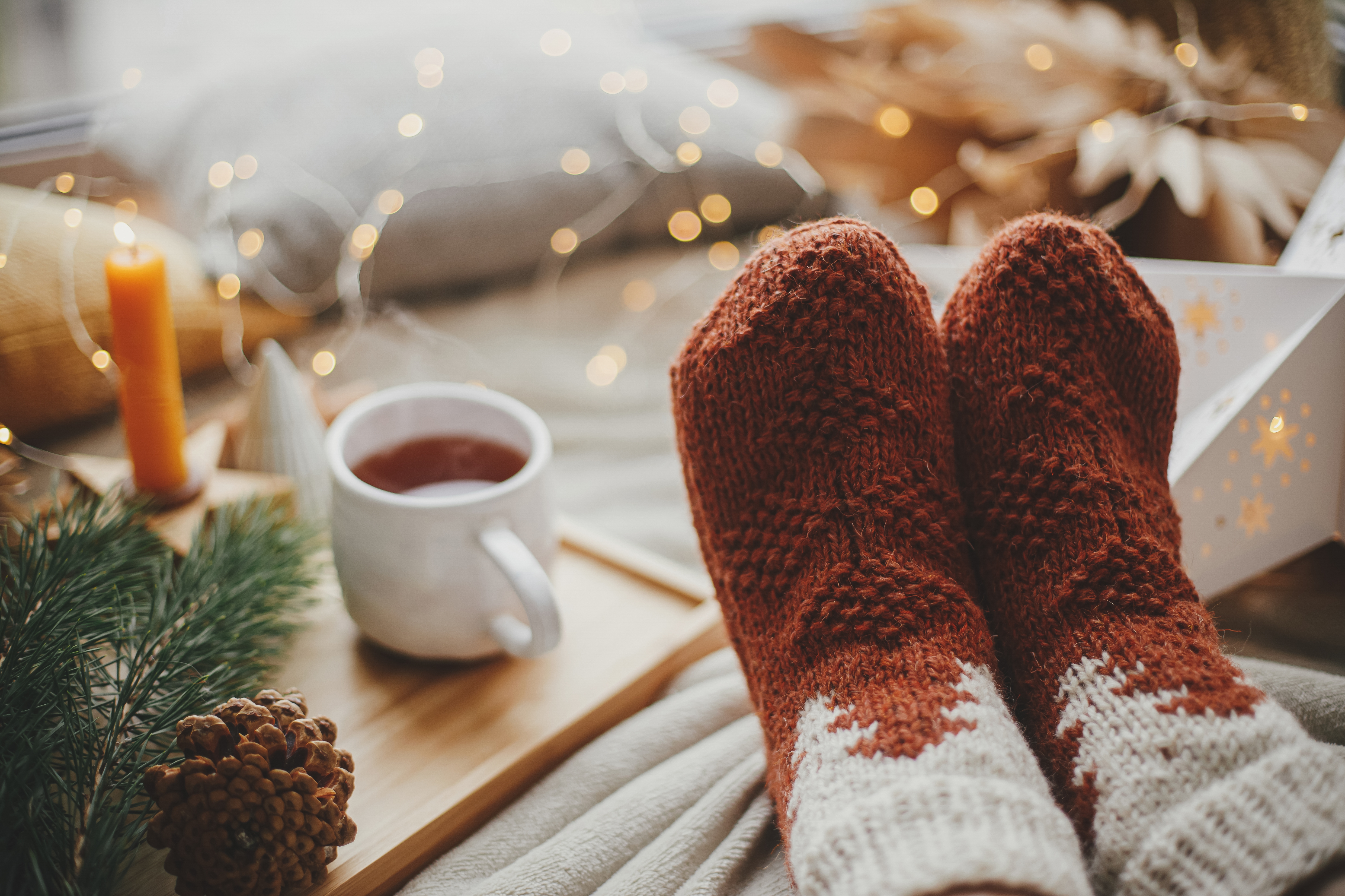 Eine Person in kuscheligen Socken mit Tee | Quelle: Shutterstock