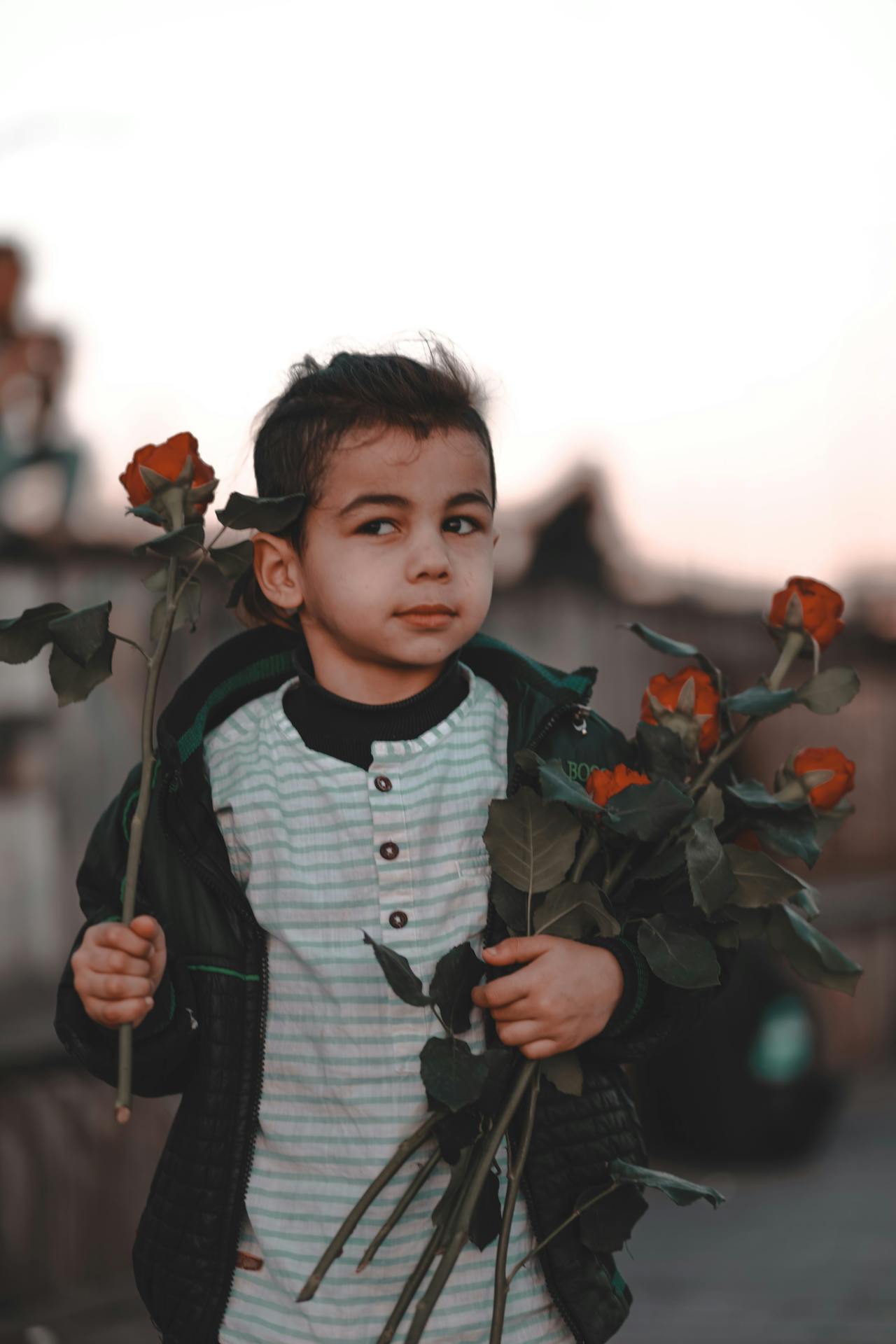Ein kleiner Junge hält einen Strauß roter Rosen | Quelle: Pexels