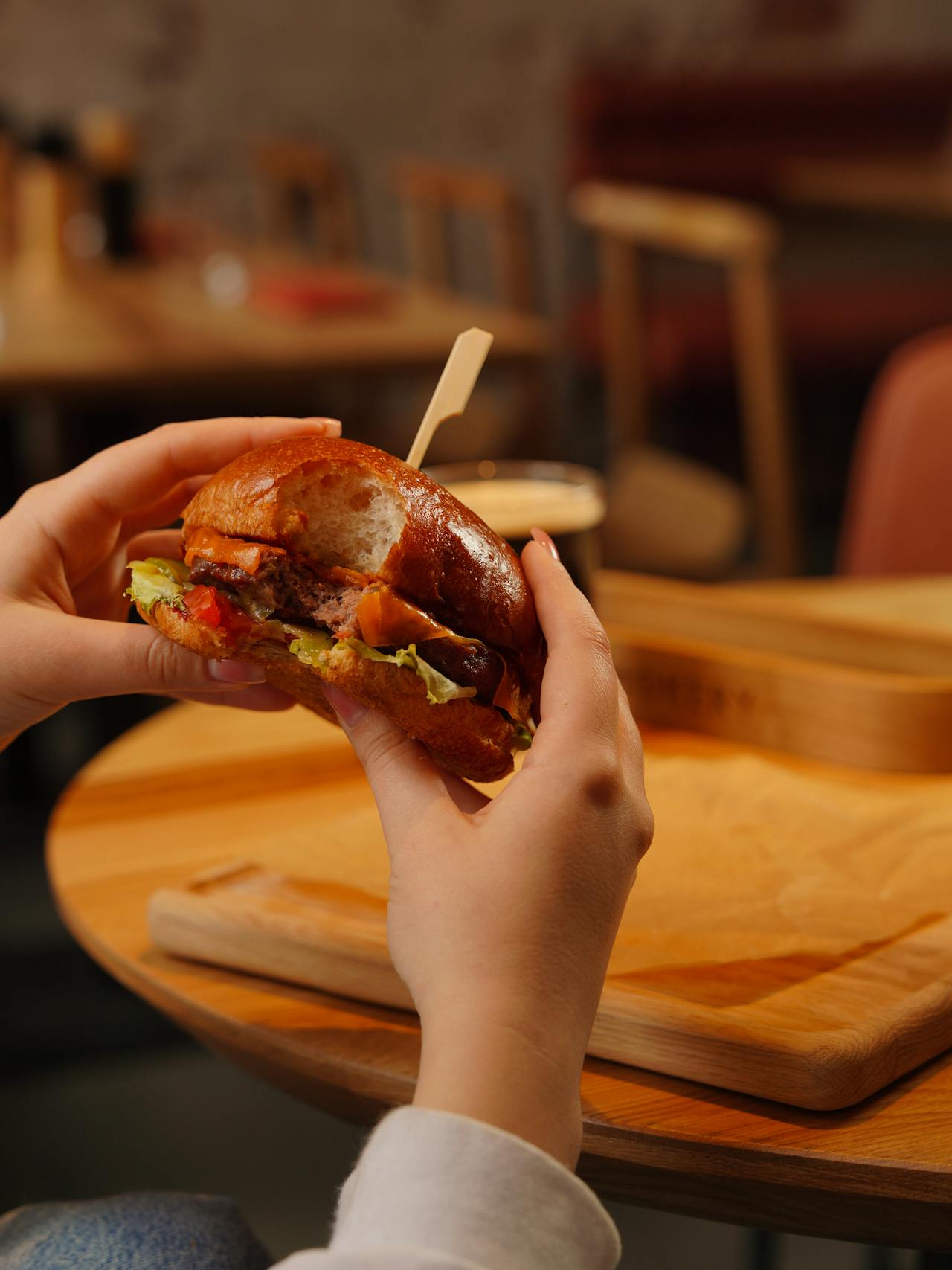 Eine Frau beim Essen eines Burgers | Quelle: Pexels