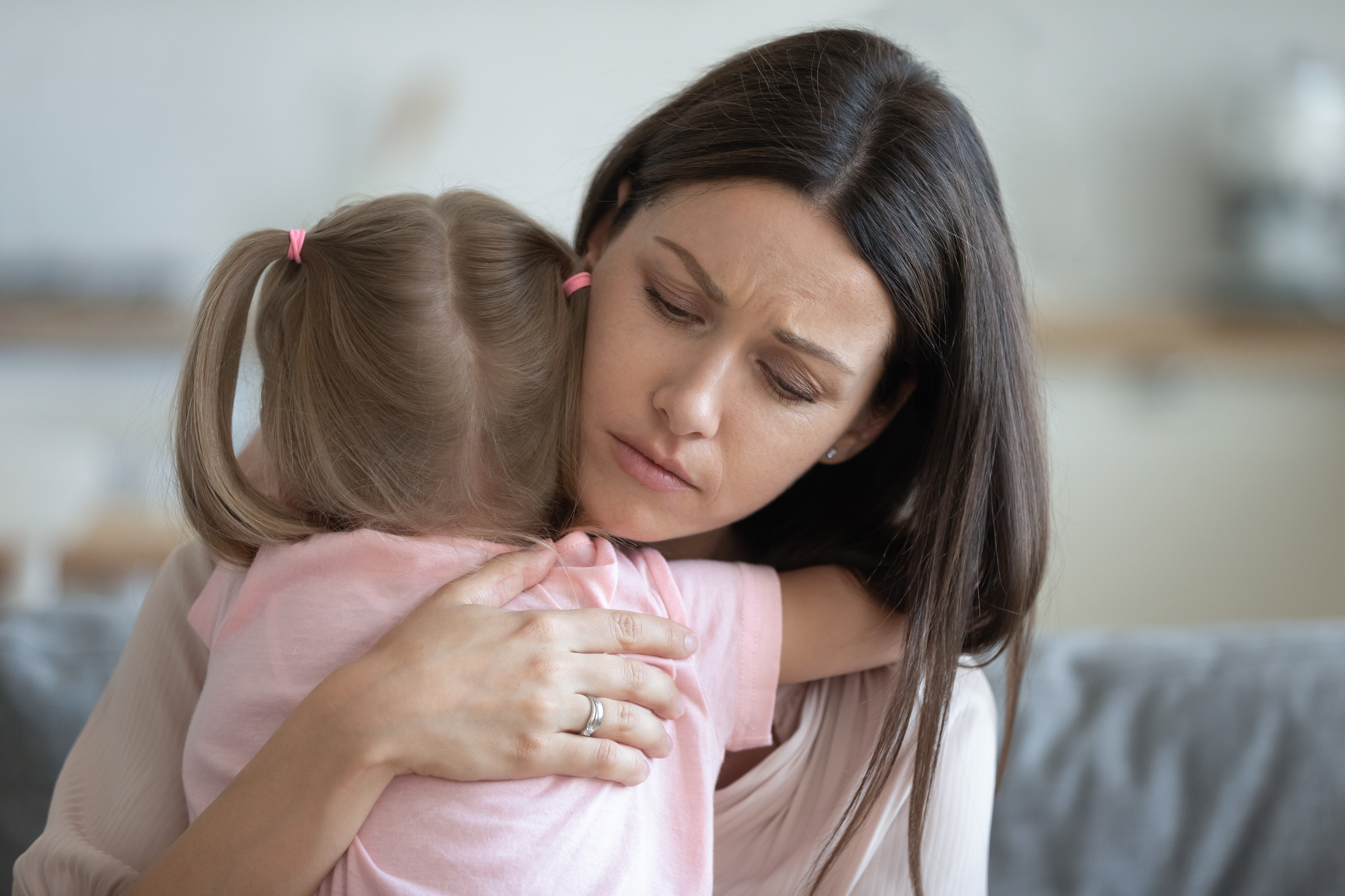 Besorgte junge Mutter hält ihre Tochter im Arm | Quelle: Shutterstock