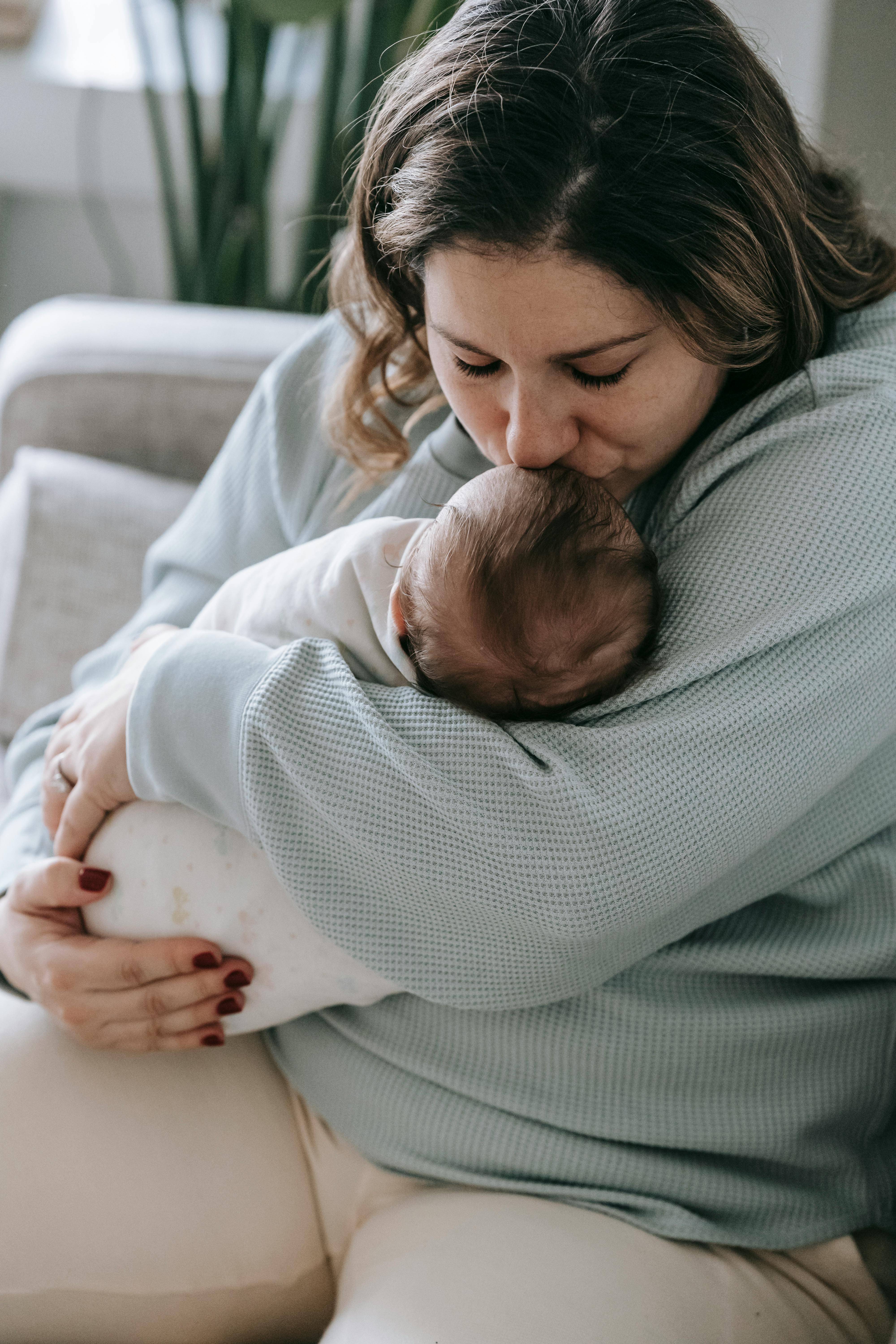 Eine Frau küsst ihr Baby auf die Stirn | Quelle: Pexels