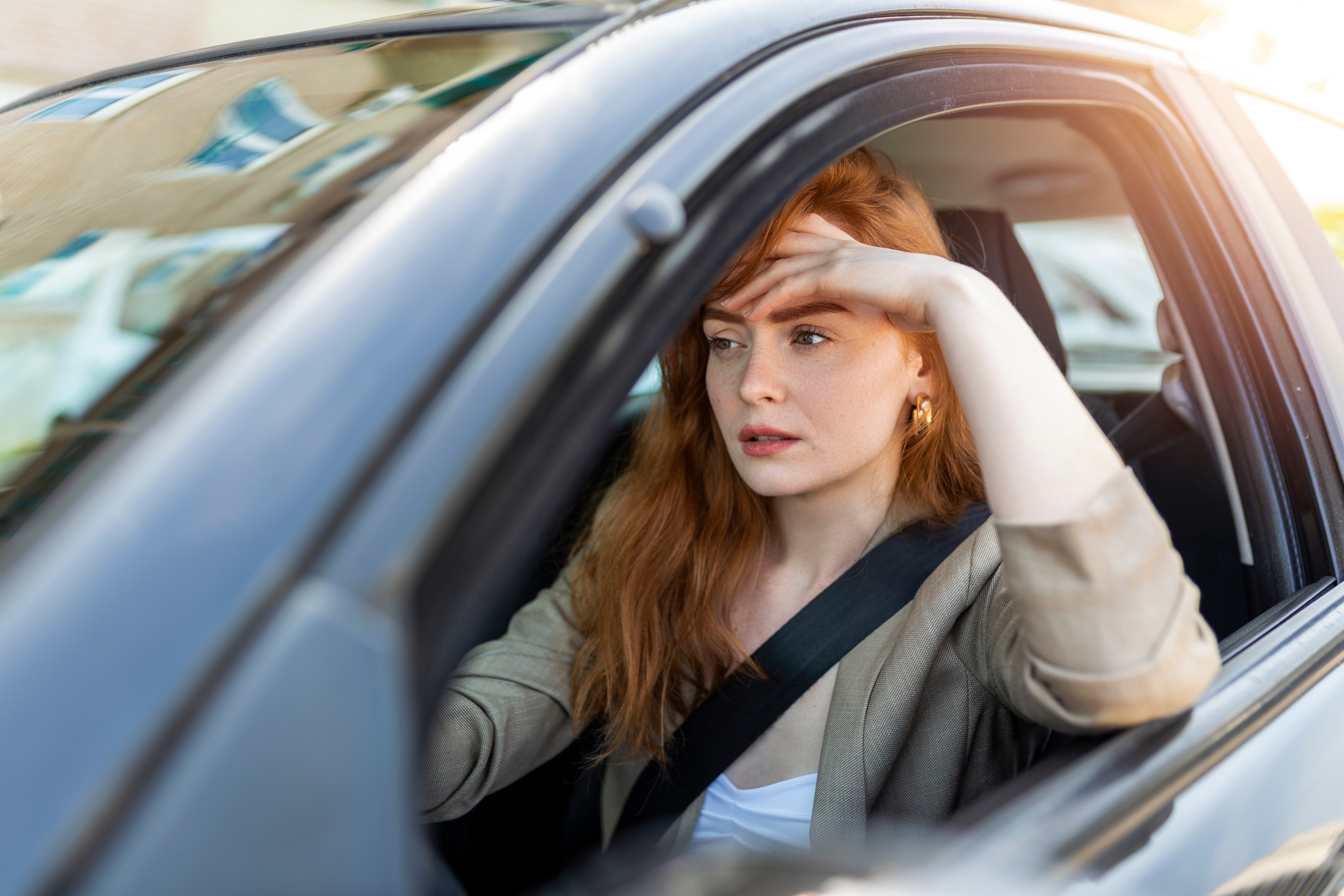 Eine Frau, die aussieht, als sei sie beim Autofahren in Gedanken versunken | Quelle: Shutterstock