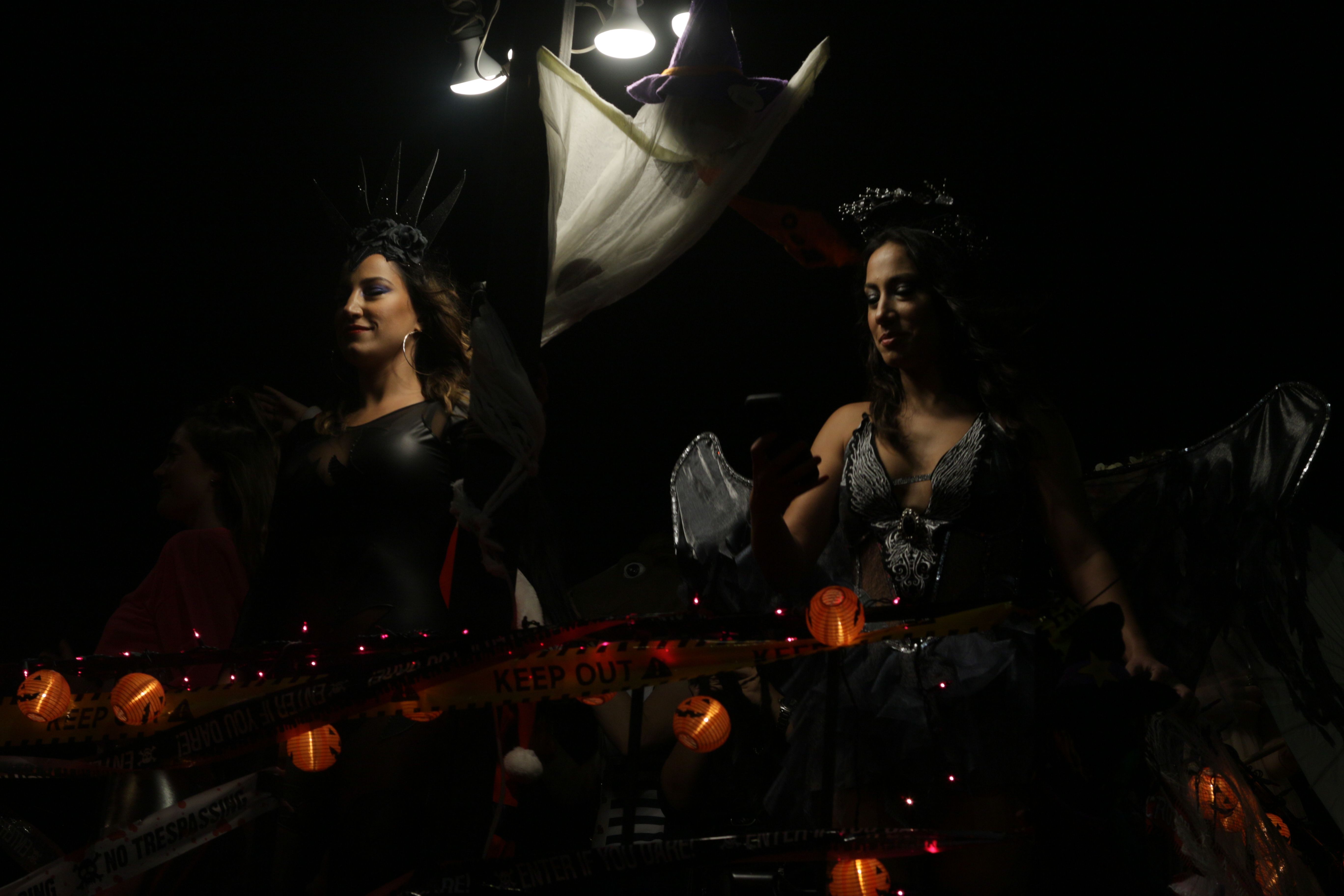 Frauen in Halloween-Kostümen nehmen an einer lebhaften nächtlichen Parade teil und präsentieren festliche Dekorationen | Quelle: Pexels