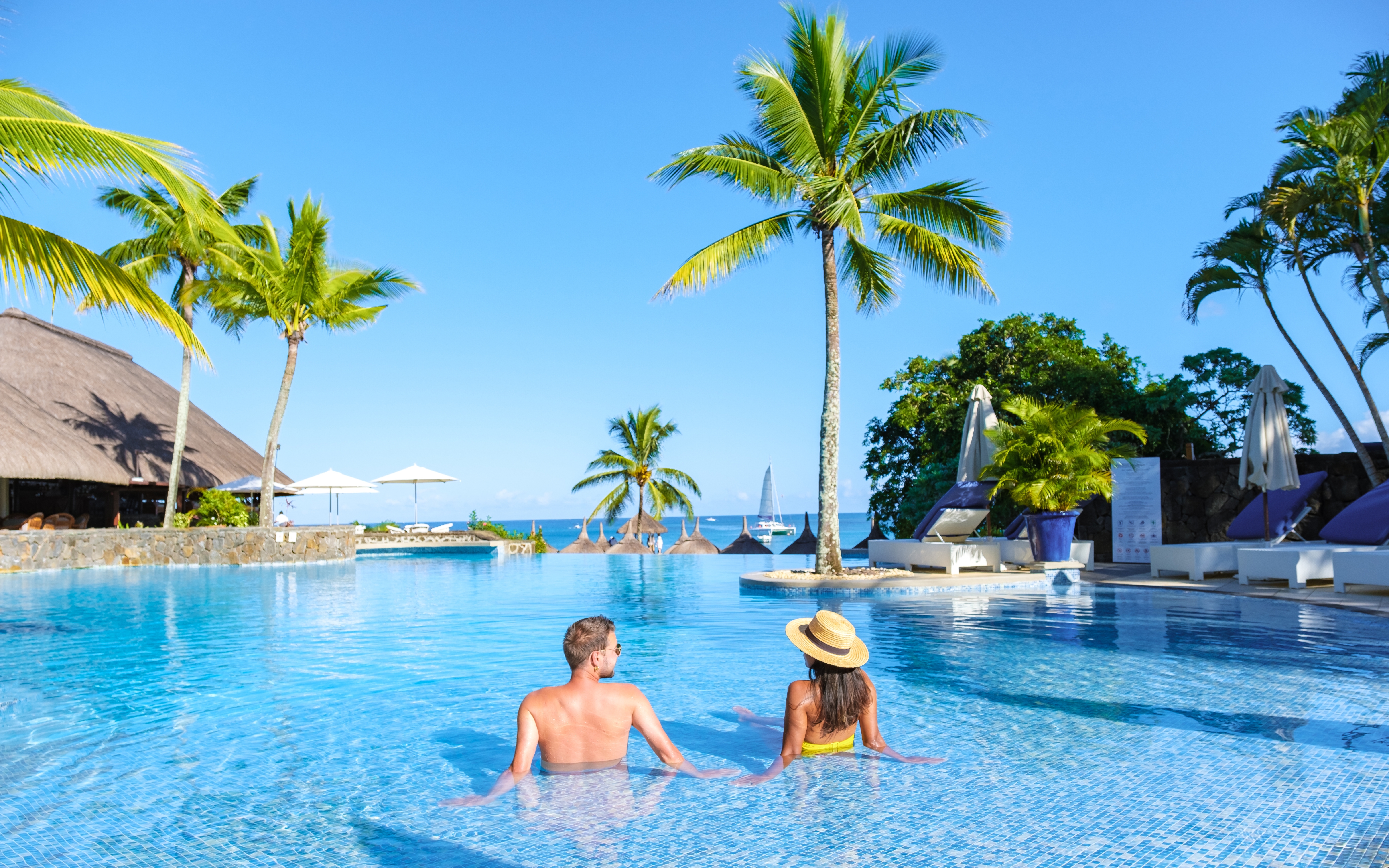 Ein Paar, das sich im Urlaub in einem Swimmingpool entspannt | Quelle: Shutterstock