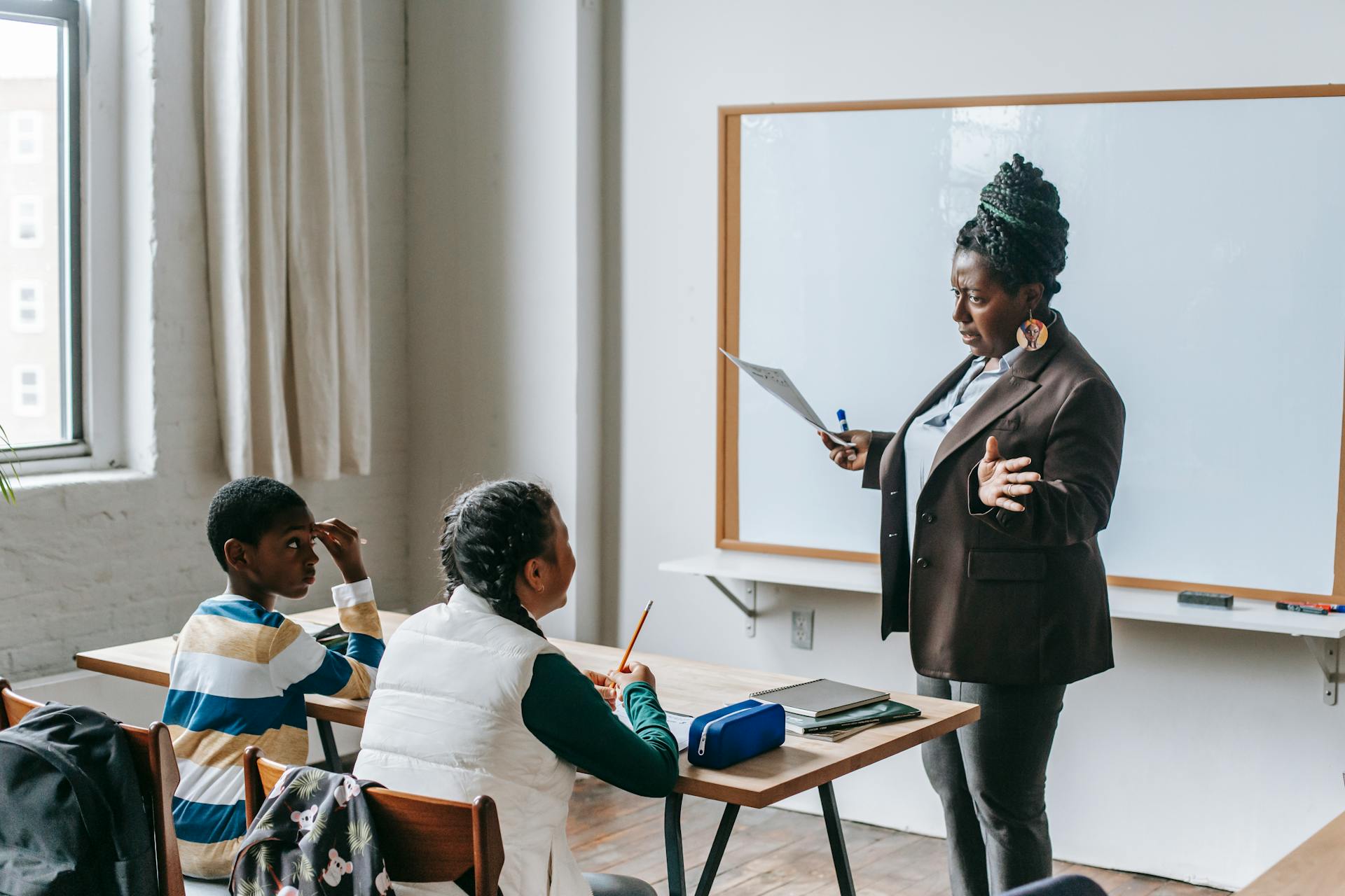 Eine Lehrerin mit Schülern in einem Klassenzimmer | Quelle: Pexels