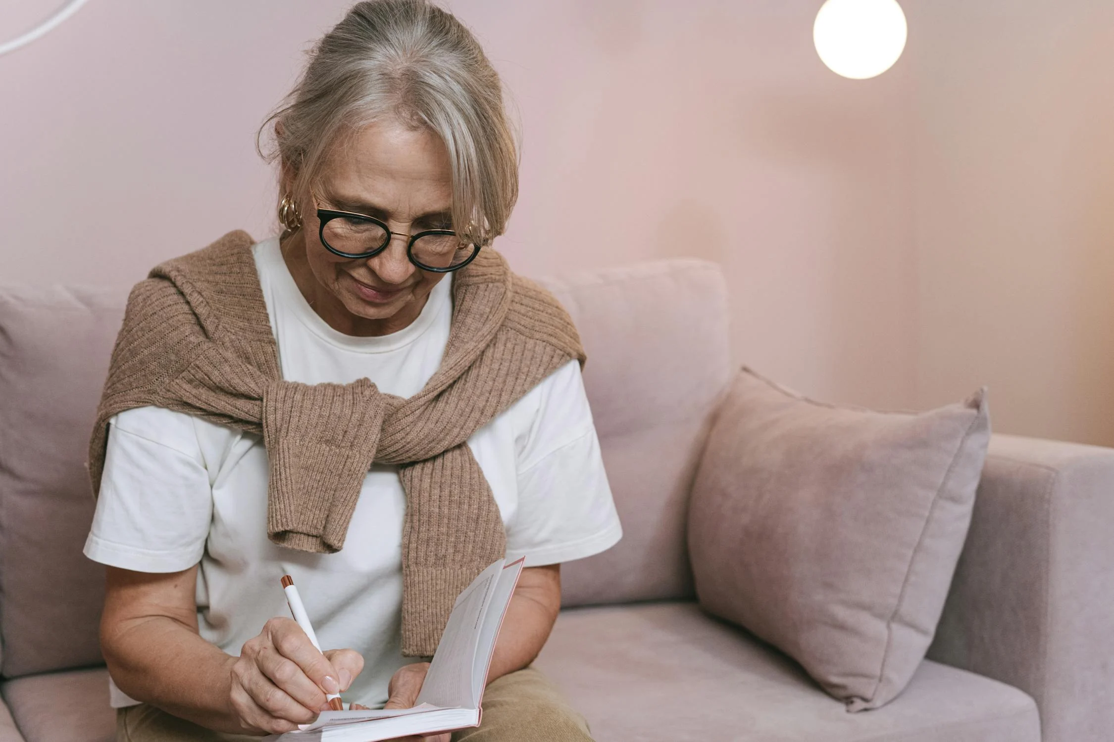 Eine Frau schreibt in ihr Notizbuch | Quelle: Pexels