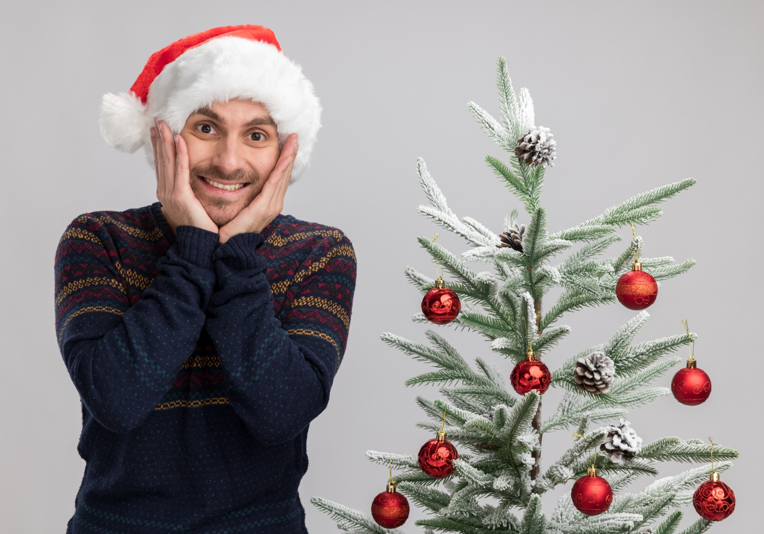 Ein aufgeregter Mann steht neben einem Weihnachtsbaum | Quelle: Freepik