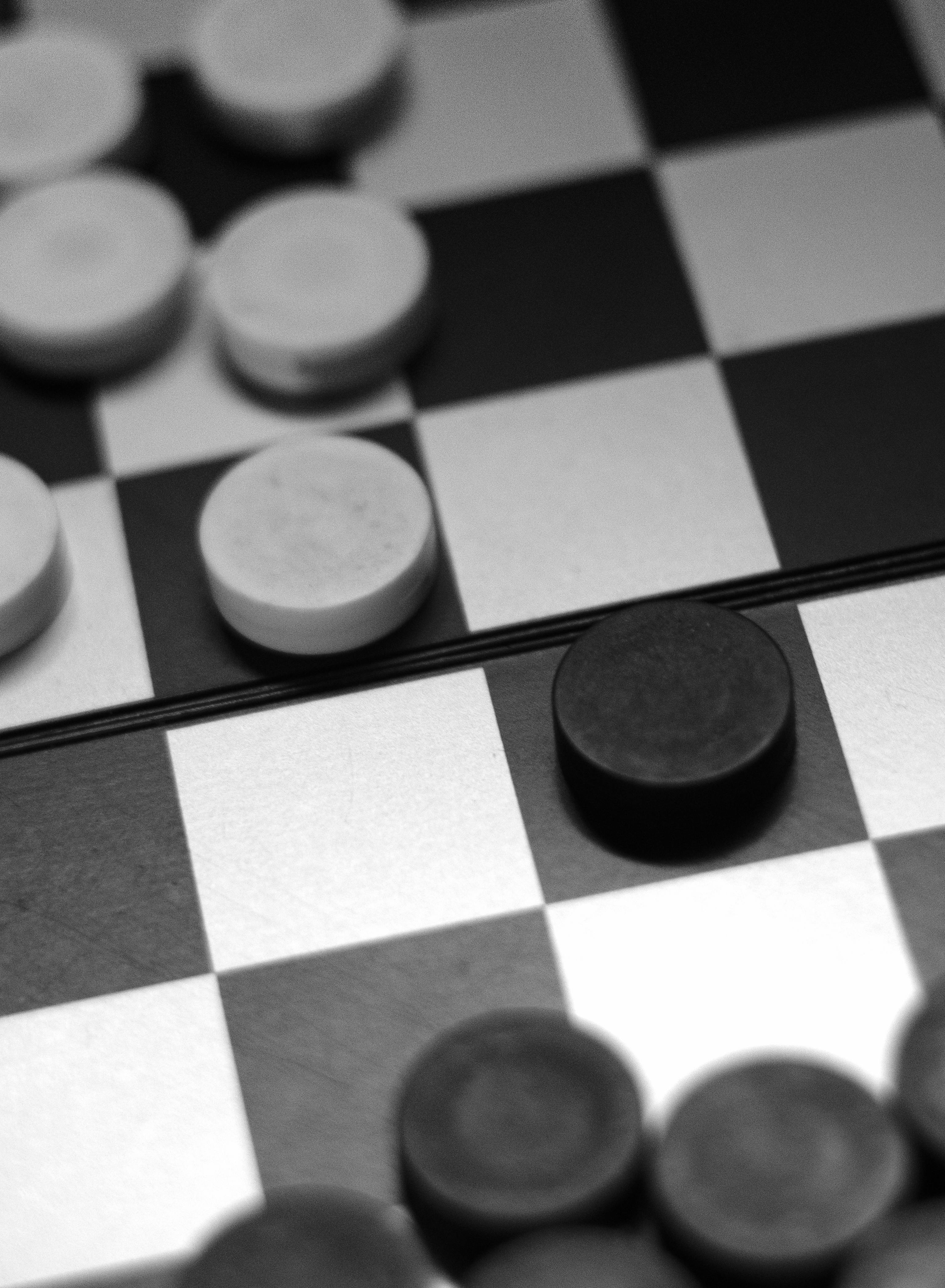 Schwarze und weiße Spielsteine auf einem Brett | Quelle: Pexels