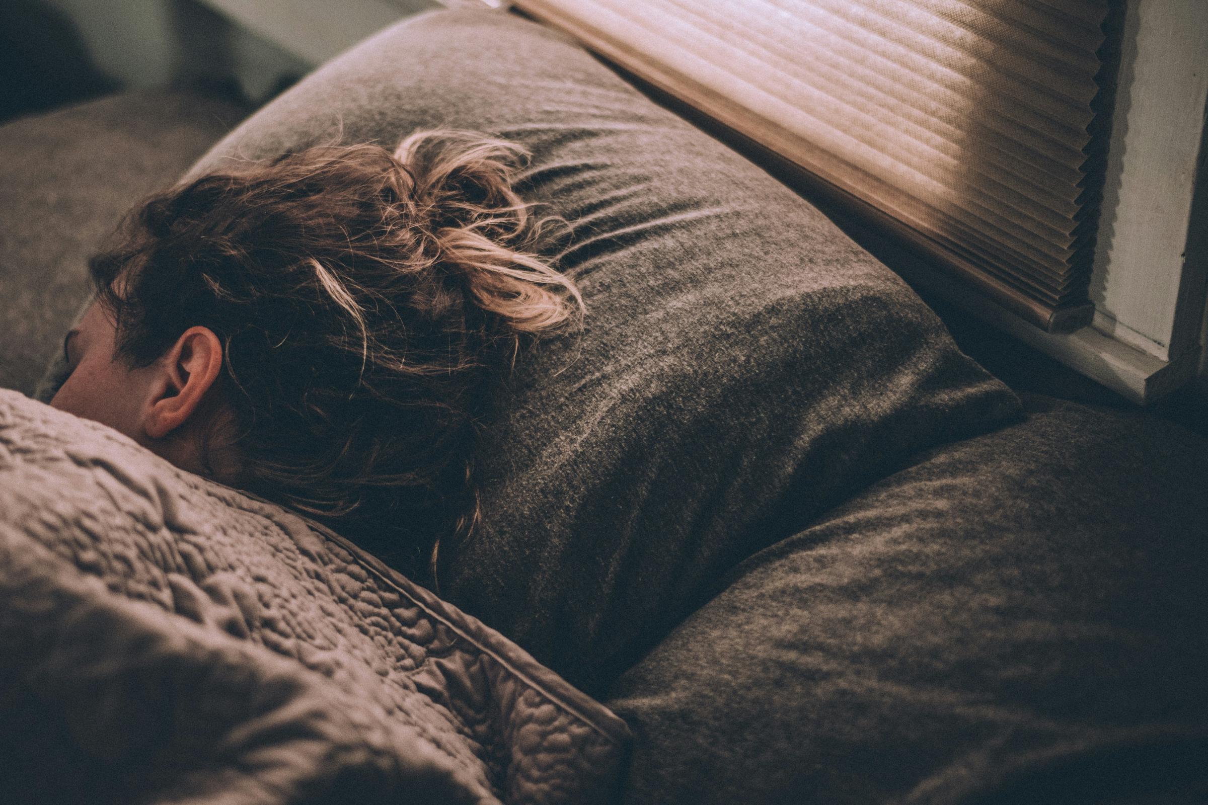 Eine Frau schläft in einem bequemen Bett | Quelle: Unsplash