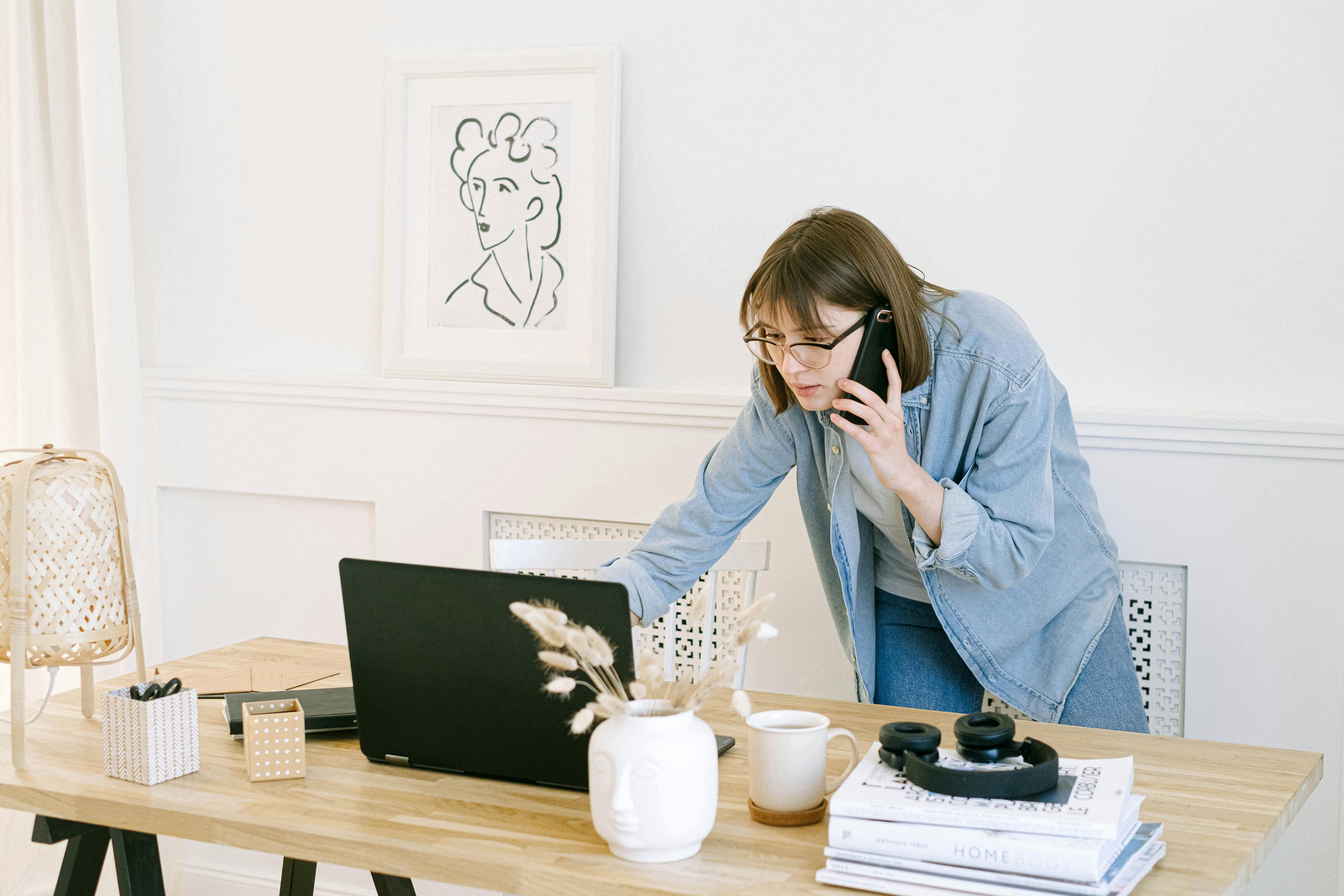 Frau telefoniert und schaut auf einen Laptop | Quelle: Pexels