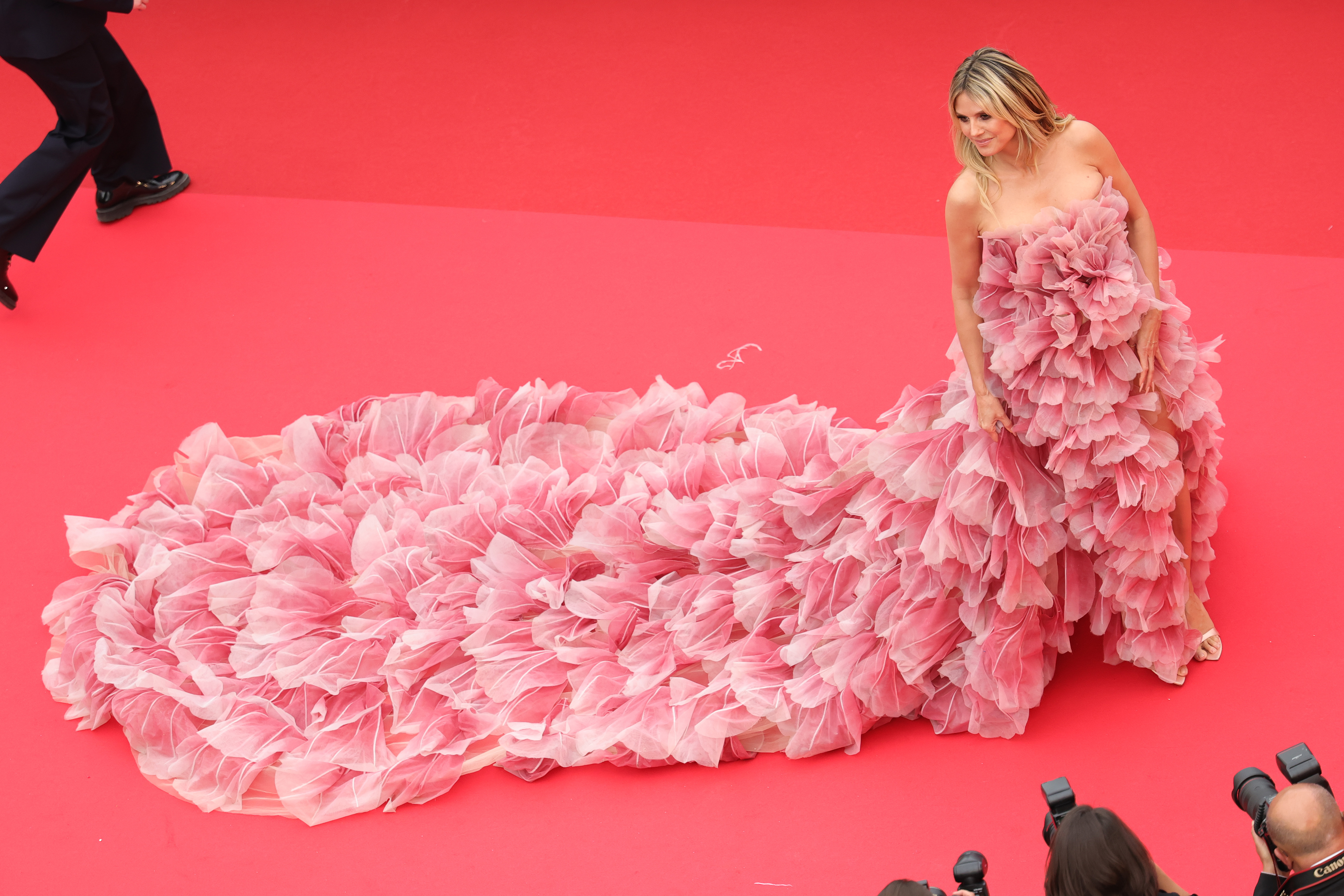 Eine makellose Luftaufnahme fängt die ganze Dramatik von Klums Kleid ein, dessen kaskadenförmige Schleppe anmutig hinter ihr herfließt. Die atemberaubende Aussicht macht deutlich, warum sie die Regeln beugte, um ein solch atemberaubendes Kleid zu tragen.