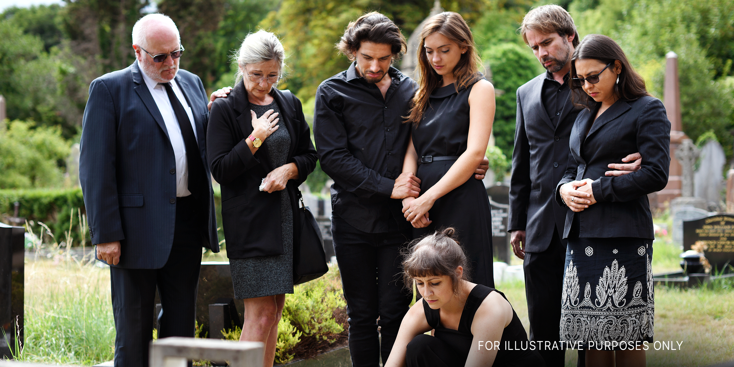 Familie legt Blumen auf dem Grab auf einem Friedhof nieder | Quelle: Shutterstock