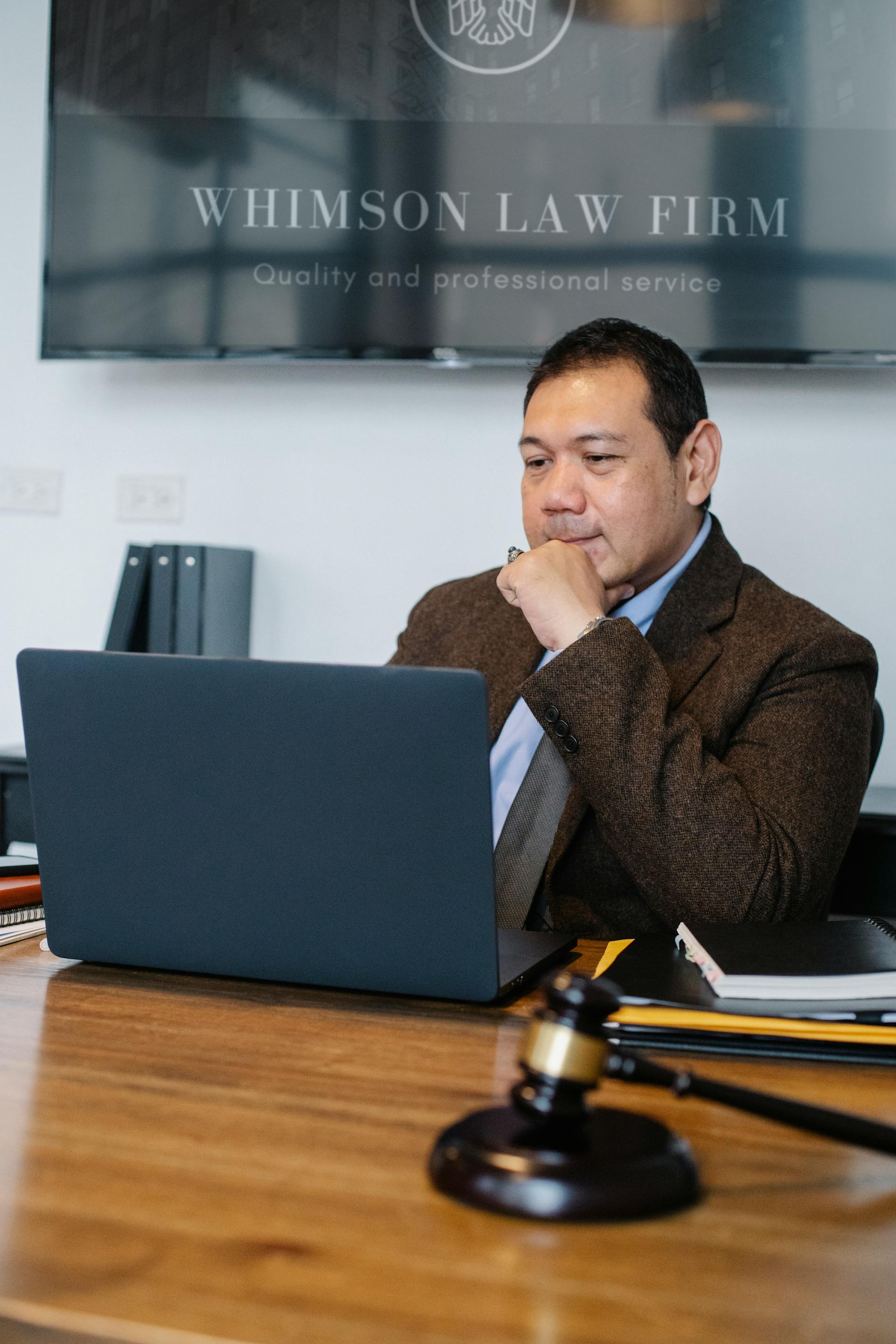 Ein männlicher Anwalt benutzt einen Laptop in seinem Büro | Quelle: Pexels