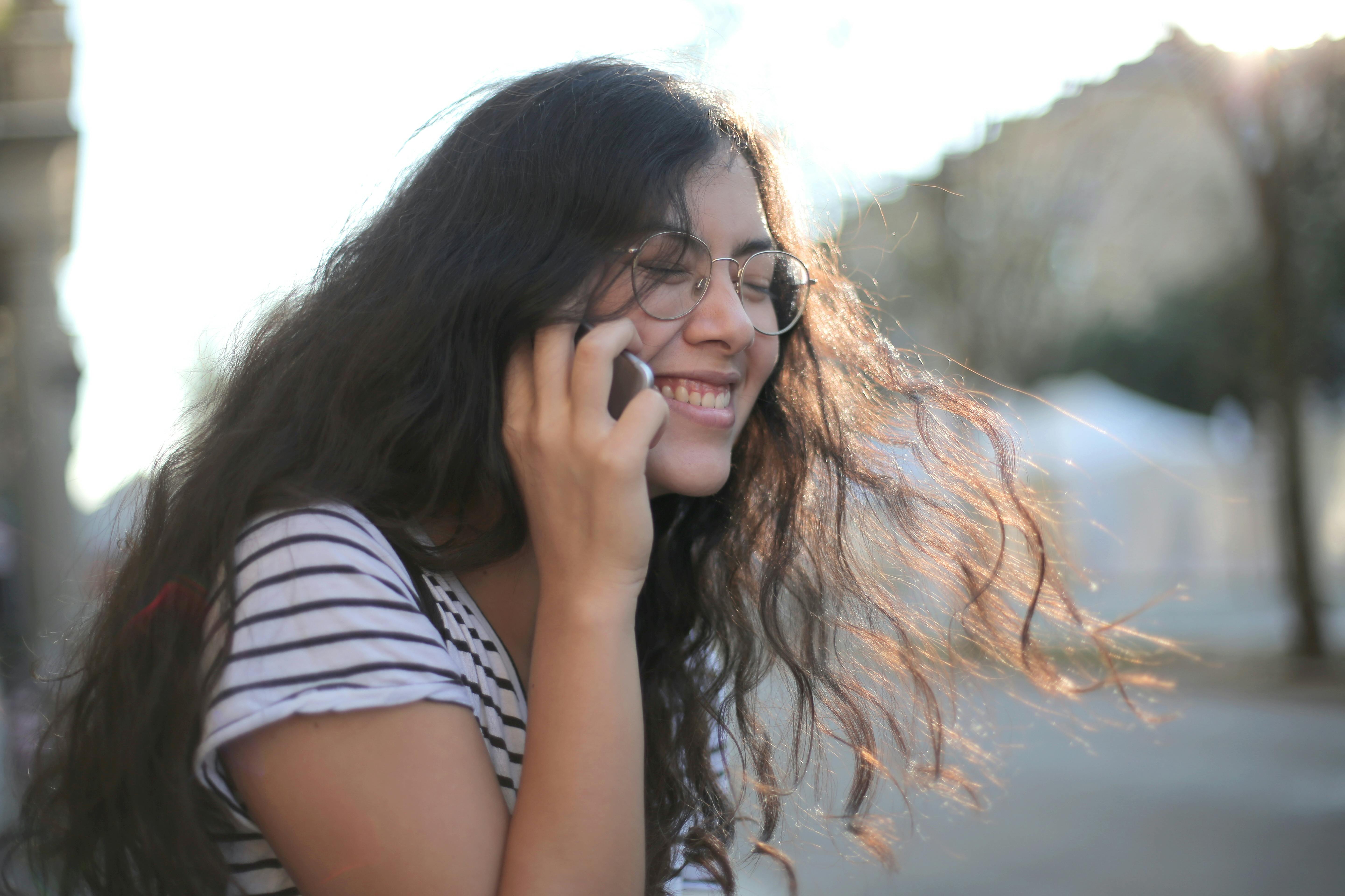 Ein lachendes Mädchen während eines Telefonats | Quelle: Pexels