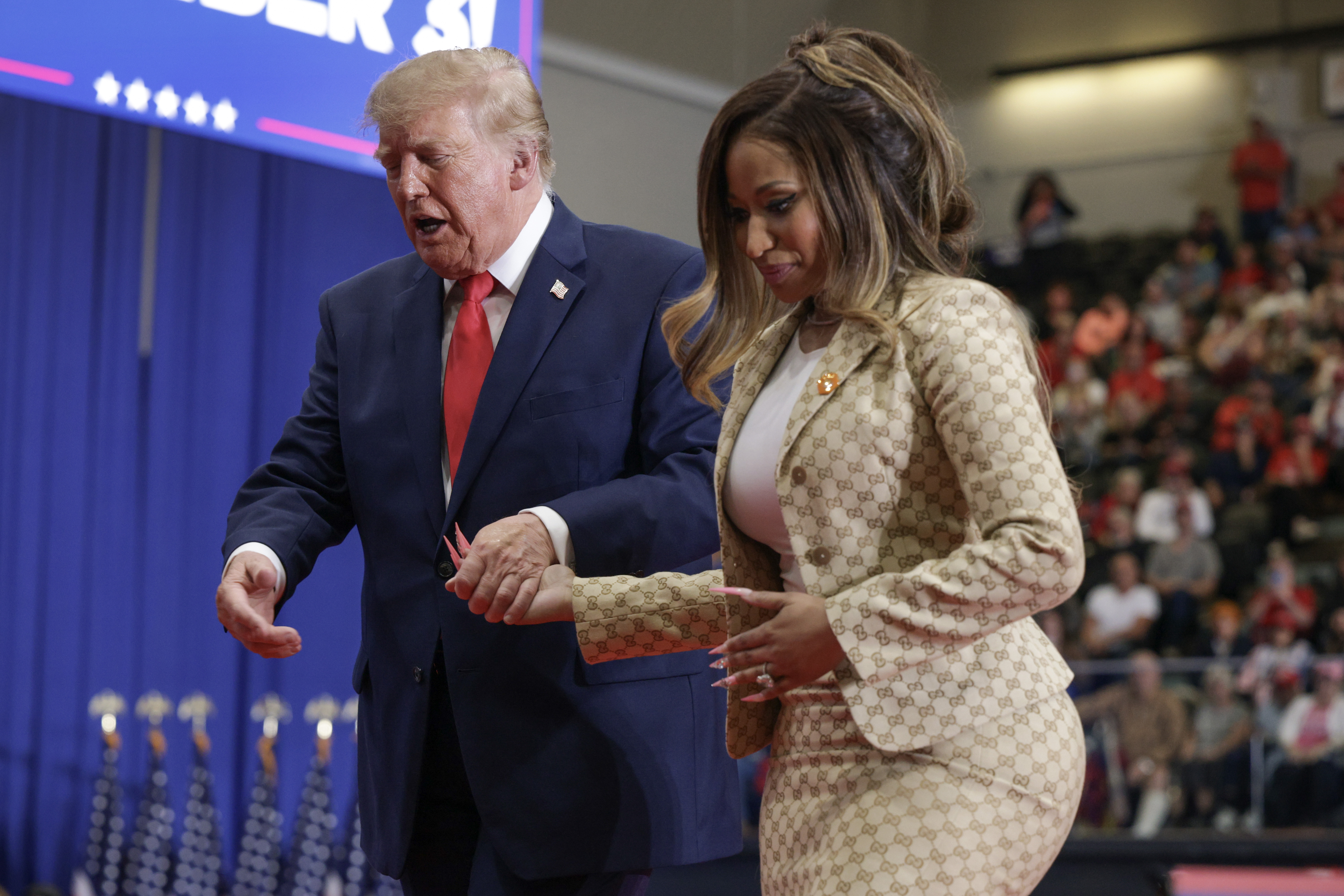 Donald Trump hält Nicki Minajs Hand, während sie über die Bühne gehen, und deutet mit seiner freien Hand nach vorne – ein Moment, der die Zuschauer zu frechen Vergleichen mit Melania Trump veranlasste. | Quelle: Getty Images