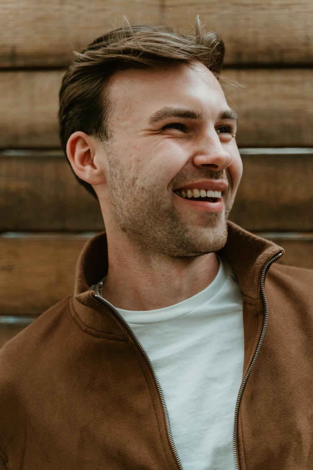 Ein lächelnder Mann schaut zur Seite | Quelle: Pexels