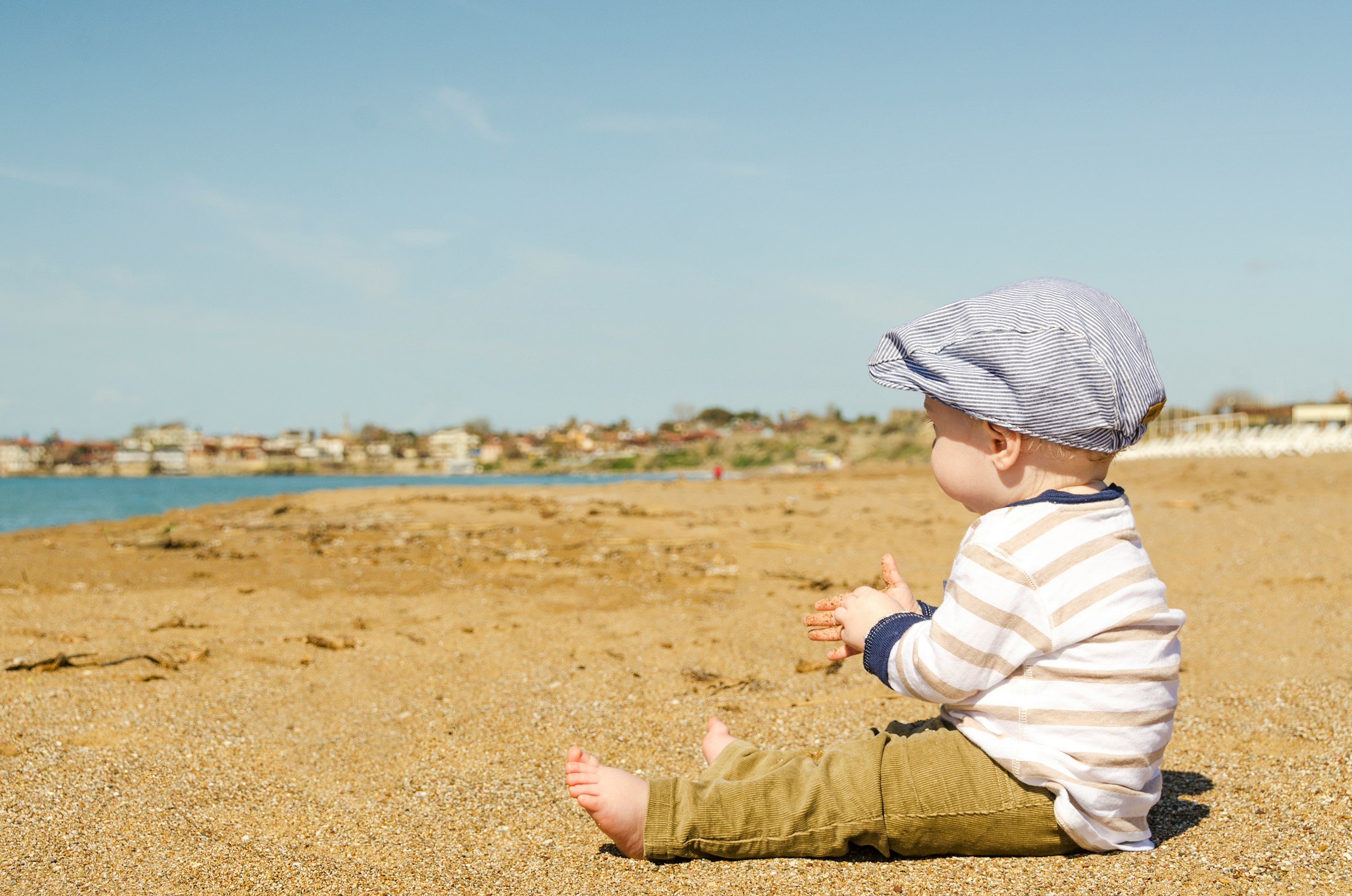 Ein kleiner Junge sitzt am Strand | Quelle: Pexels
