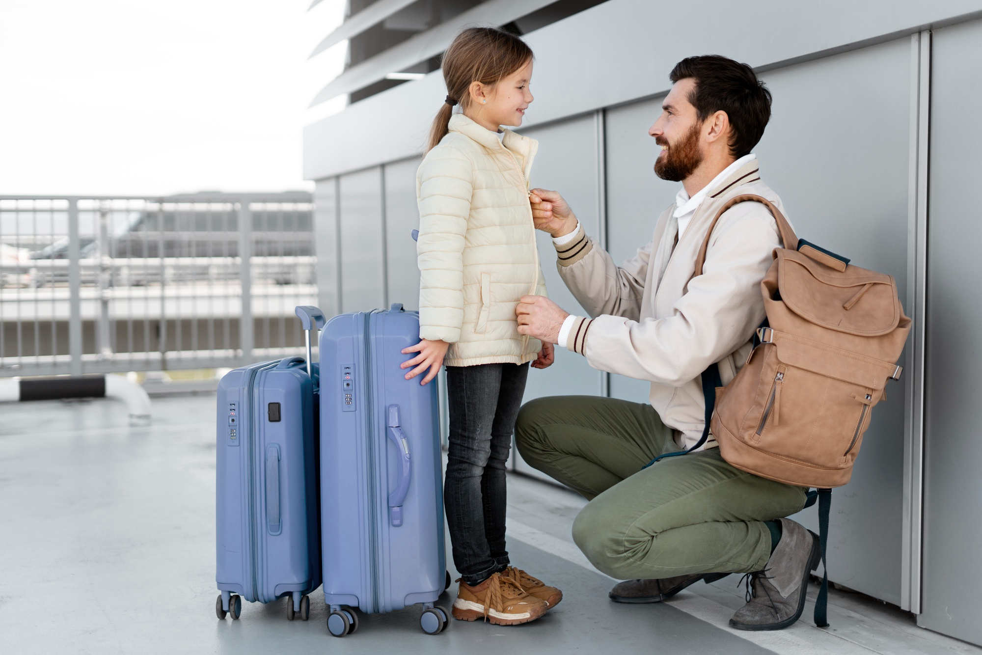 Ein Vater und seine Tochter sind bereit für ihre Reise, mit dem Gepäck in der Hand | Quelle: Freepik