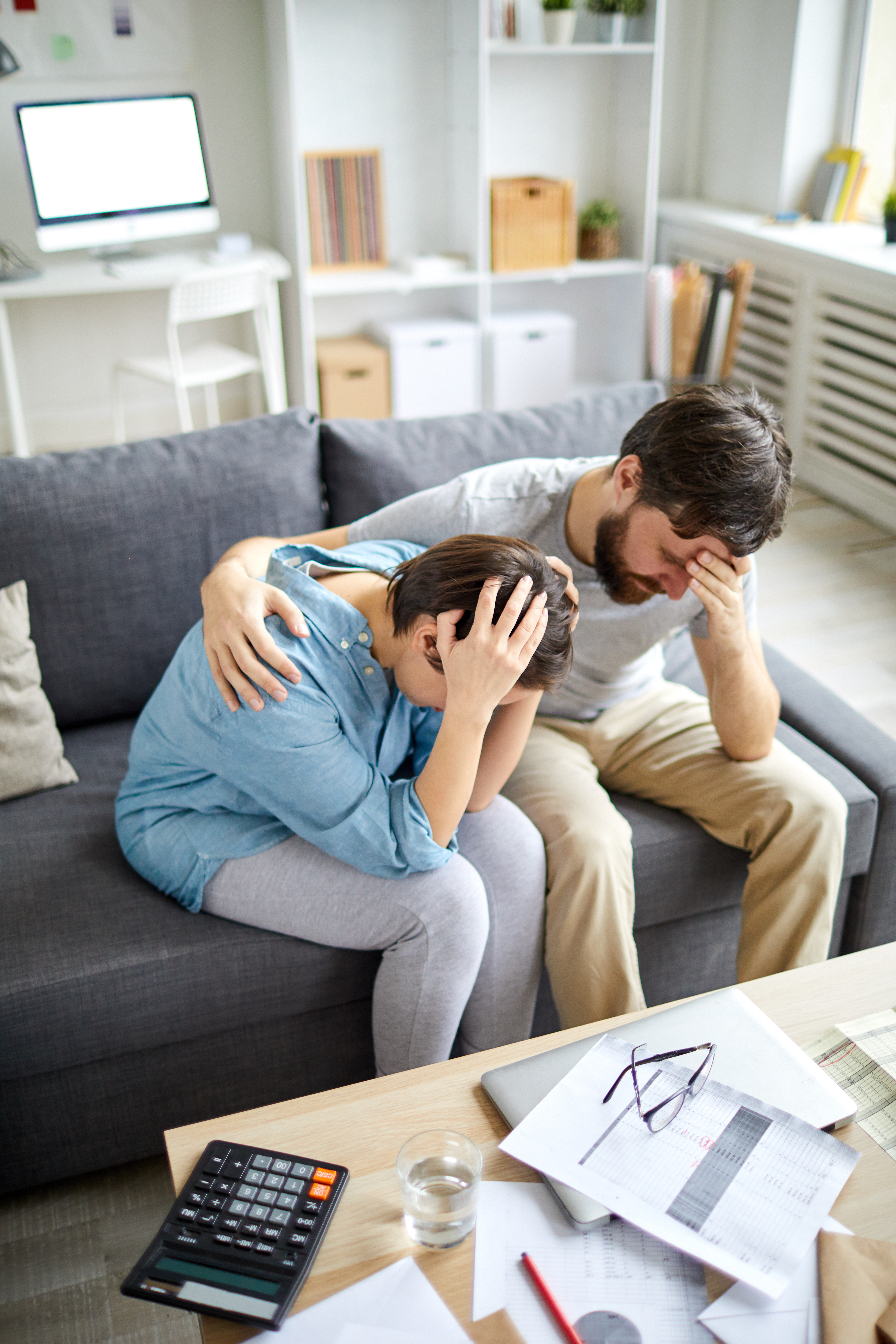 Verzweifelter Mann legt seinen Arm um eine verzweifelte Frau | Quelle: Shutterstock