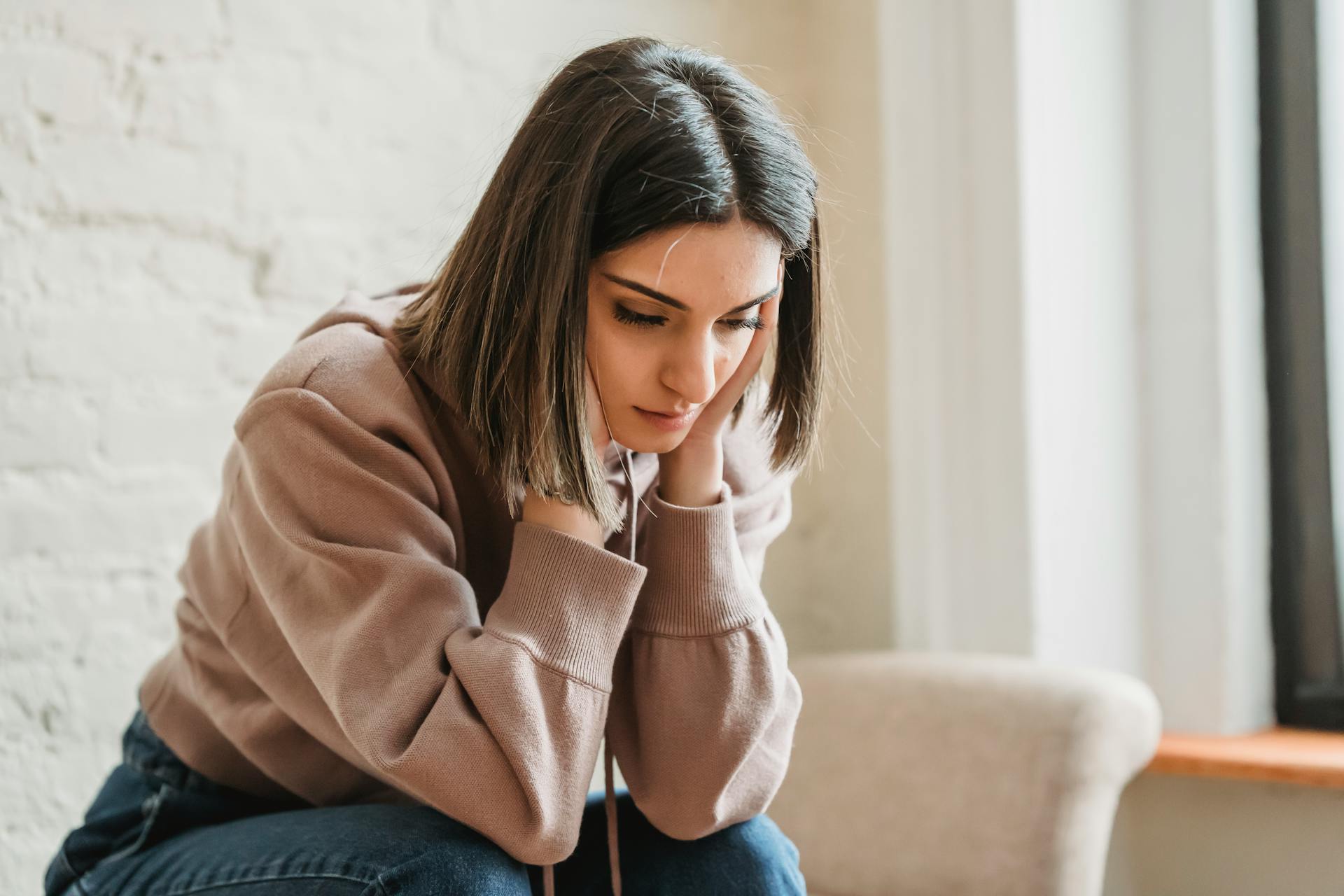 Eine ängstliche Frau sitzt auf der Couch | Quelle: Pexels