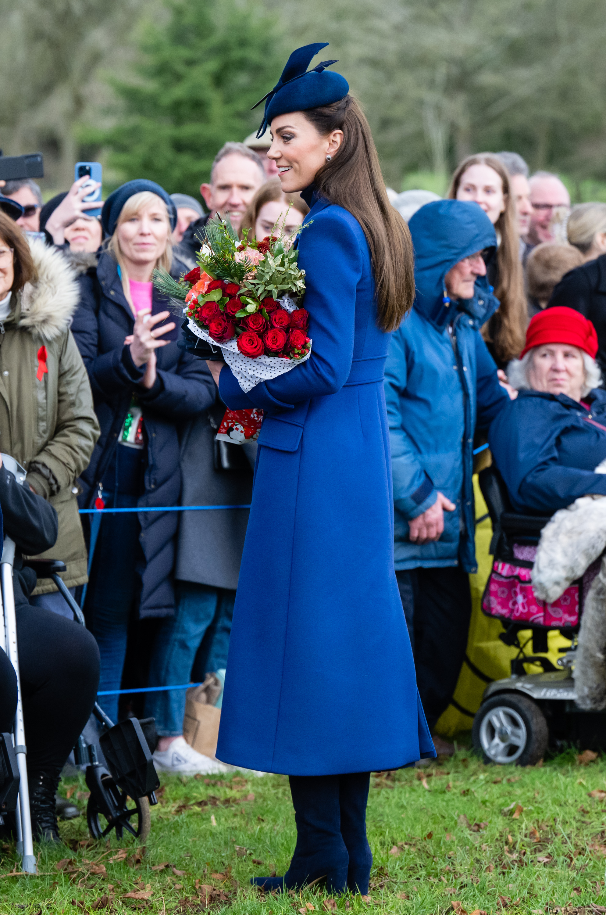 Catherine, Prinzessin von Wales, grüßt die Menge, während sie einen Rosenstrauß auf dem Weg zum Weihnachtsgottesdienst in der St. Mary Magdalene Church am 25. Dezember 2023 in Sandringham, Norfolk trägt | Quelle: Getty Images