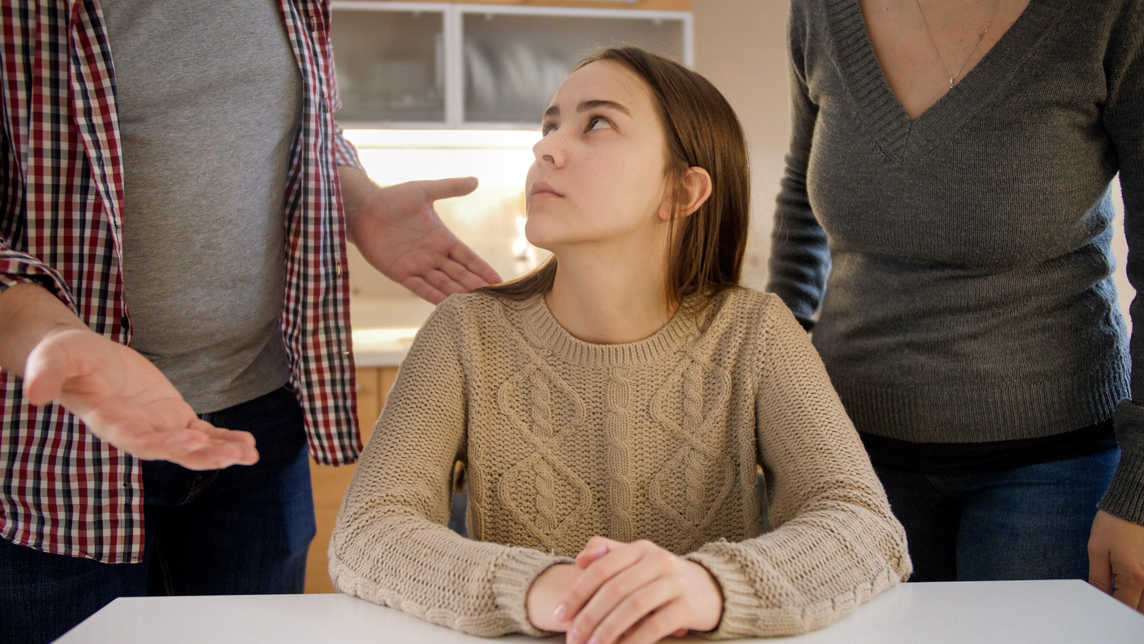 Eine verärgerte erwachsene Tochter, die ihre Eltern anschaut | Quelle: Shutterstock