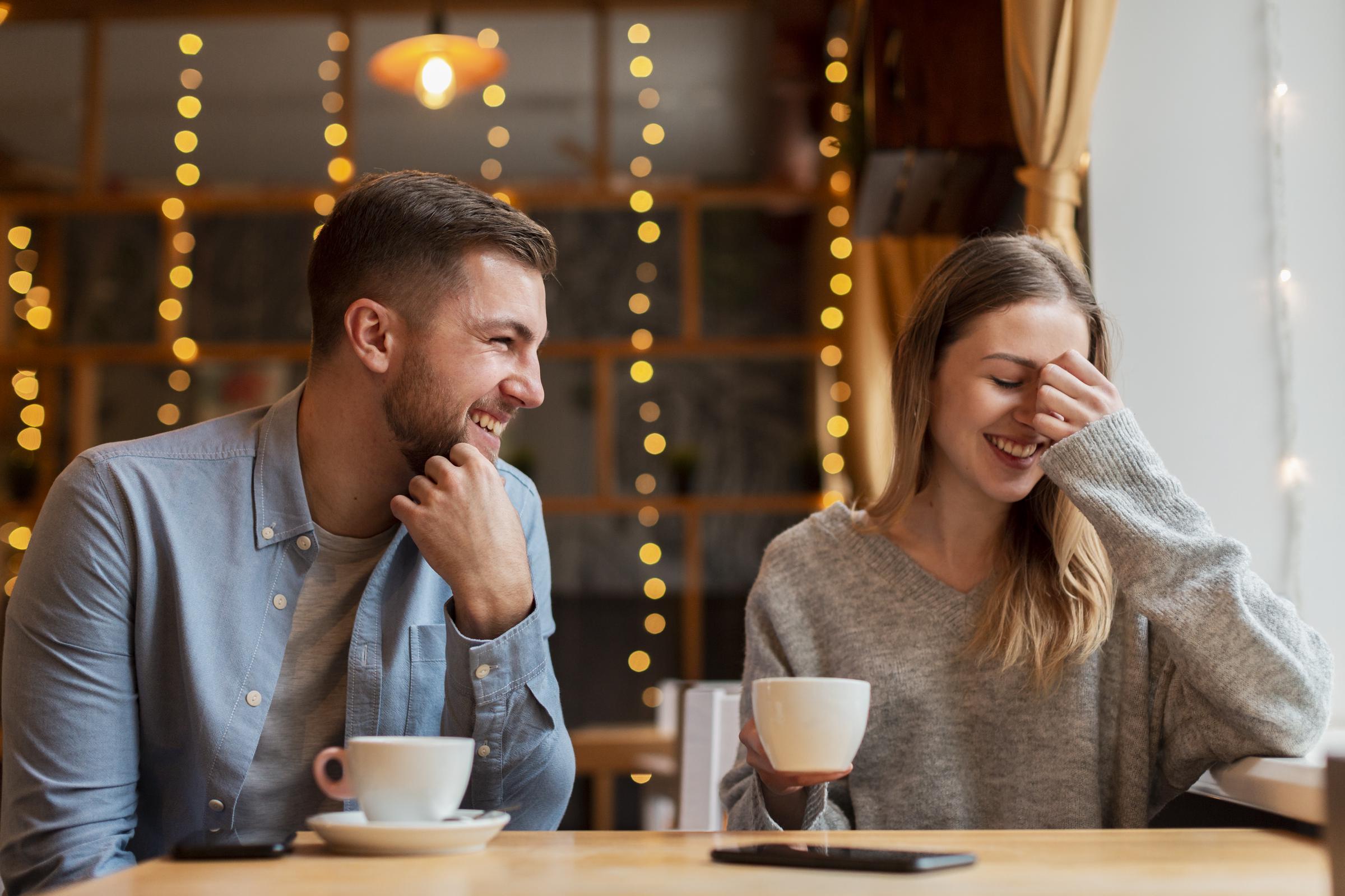 Ein Paar, das sich bei einem Kaffee amüsiert | Quelle: Freepik