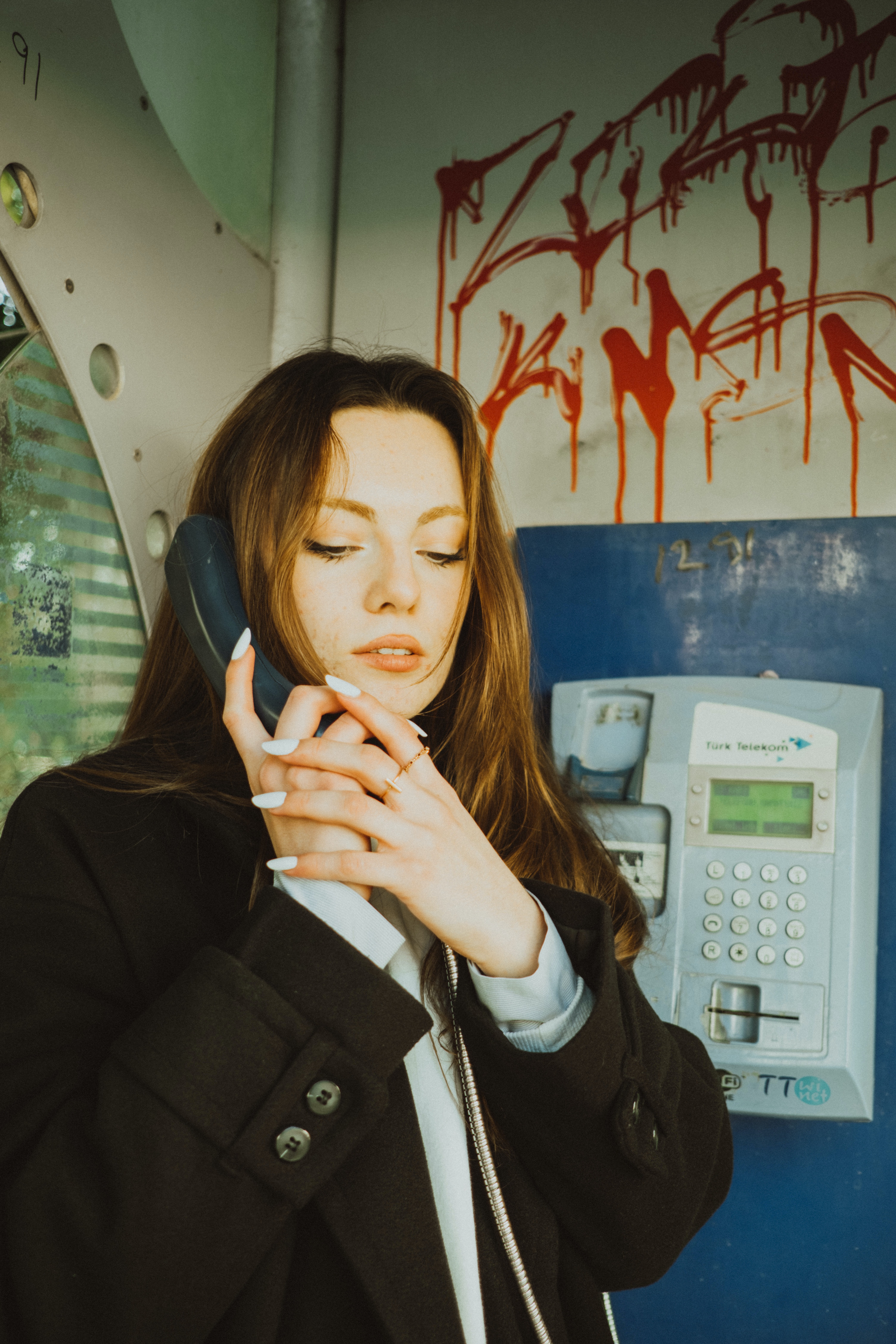 Eine Frau an einem Münztelefon | Quelle: Pexels