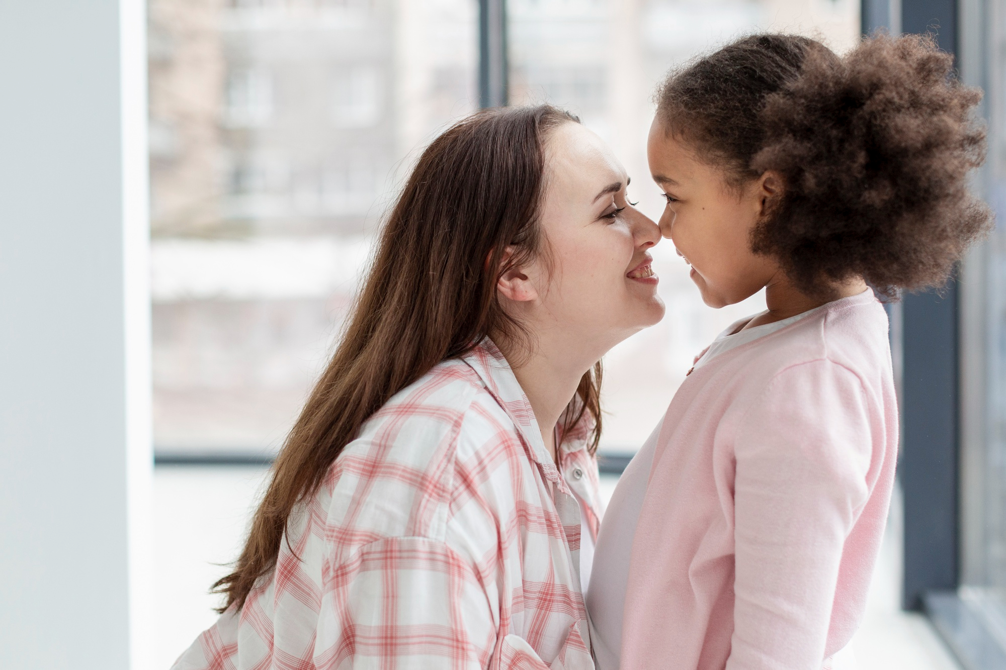 Eine Mutter reibt ihre Nase an der Nase ihrer Tochter | Quelle: Freepik