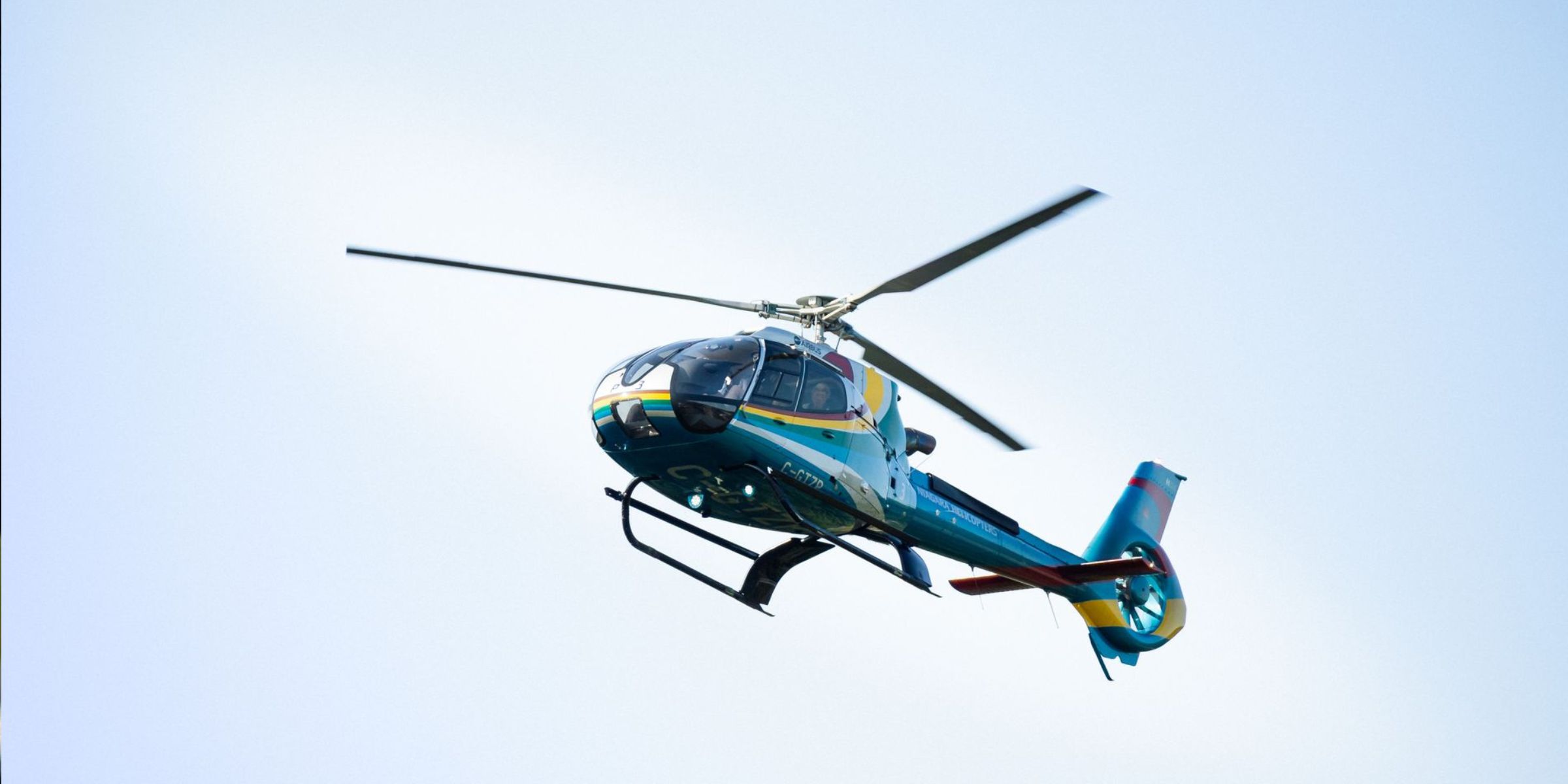 Ein bunter Hubschrauber im Flug | Quelle: Pexels