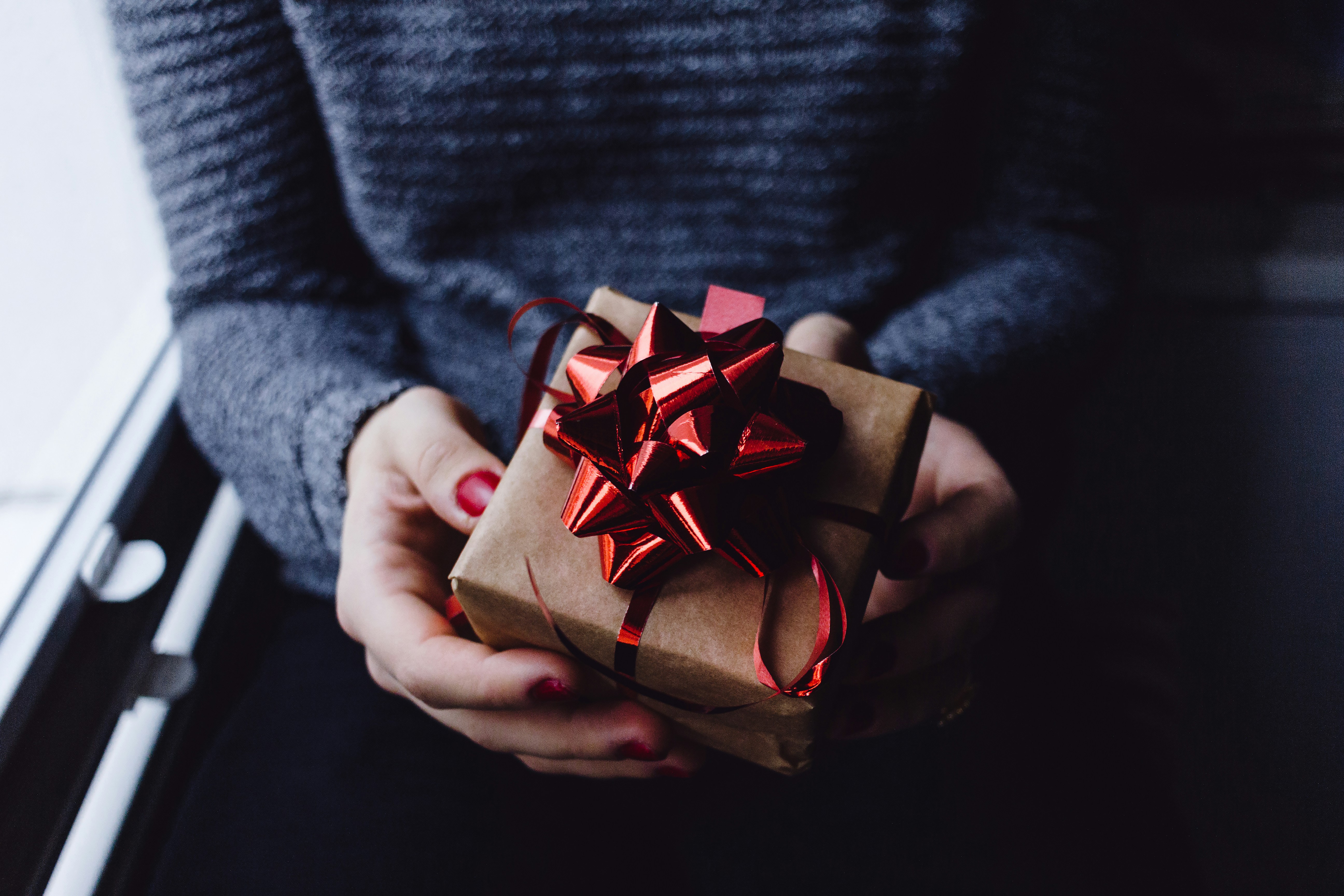 Eine Person hält ein Geschenk in den Händen | Quelle: Unsplash