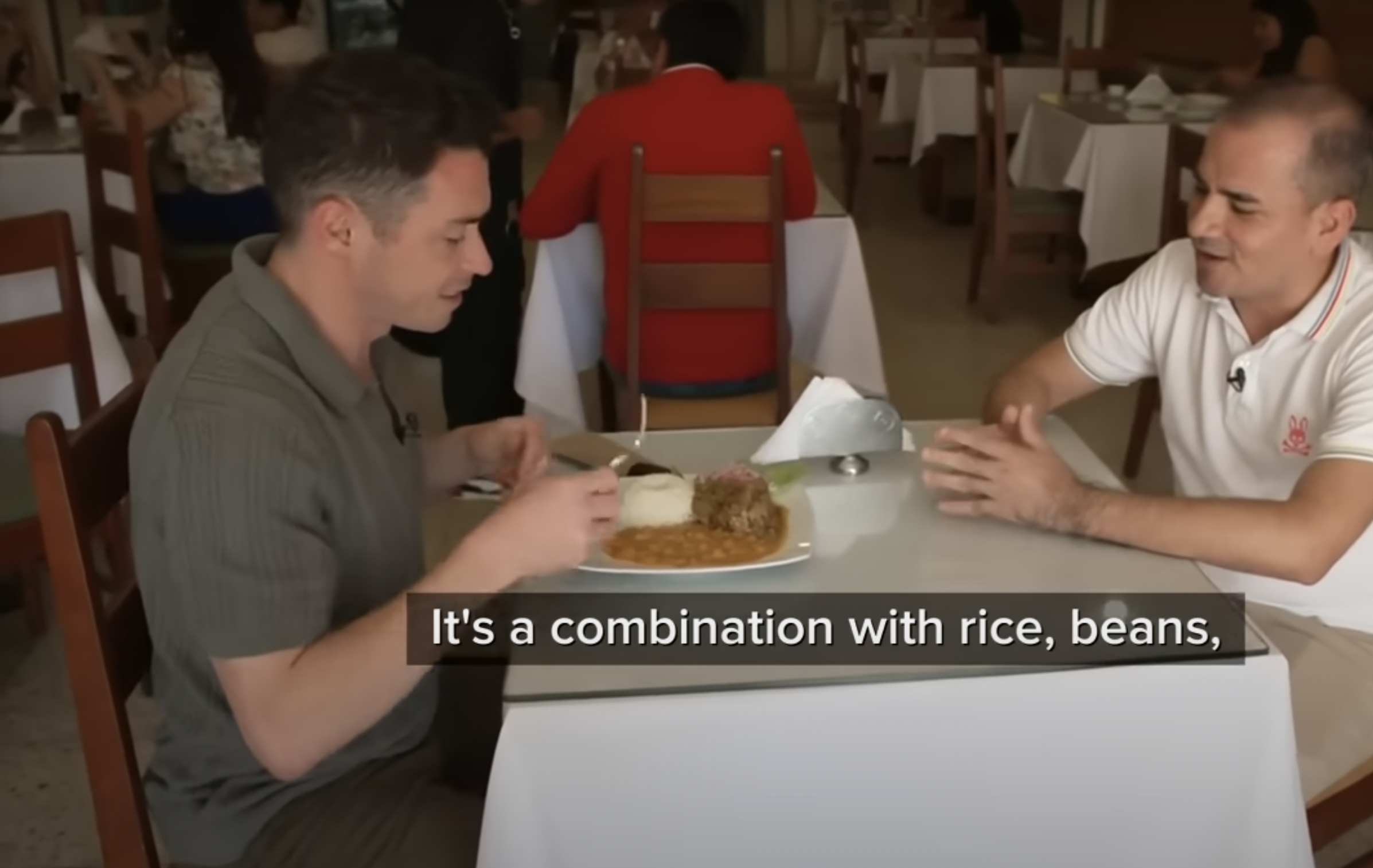 Ein Screenshot eines Reporters, der das einfache Gericht aus Reis, Bohnen und Ziegenfleisch, das Lieblingsgericht von Papst Leo XIV, genießt, aus einem Video vom 13. Mai 2025. | Quelle: YouTube/ABC News