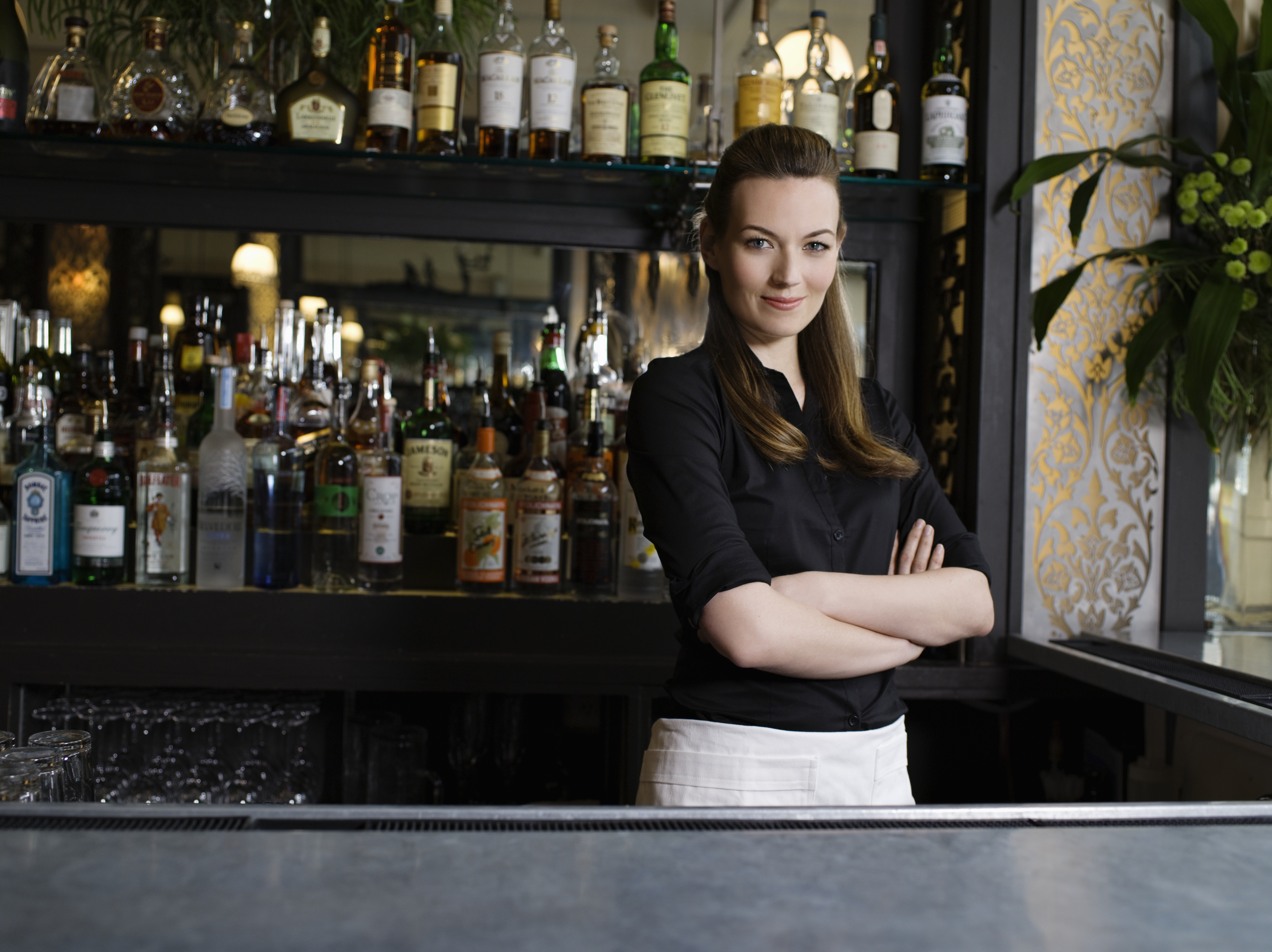 Eine selbstbewusste Barkeeperin, die hinter der Bar steht | Quelle: Getty Images