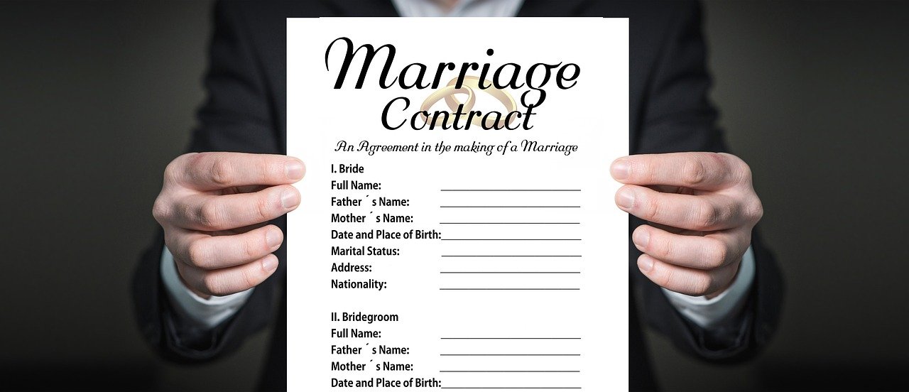 Man holds up marriage contract |  Source: Pixabay