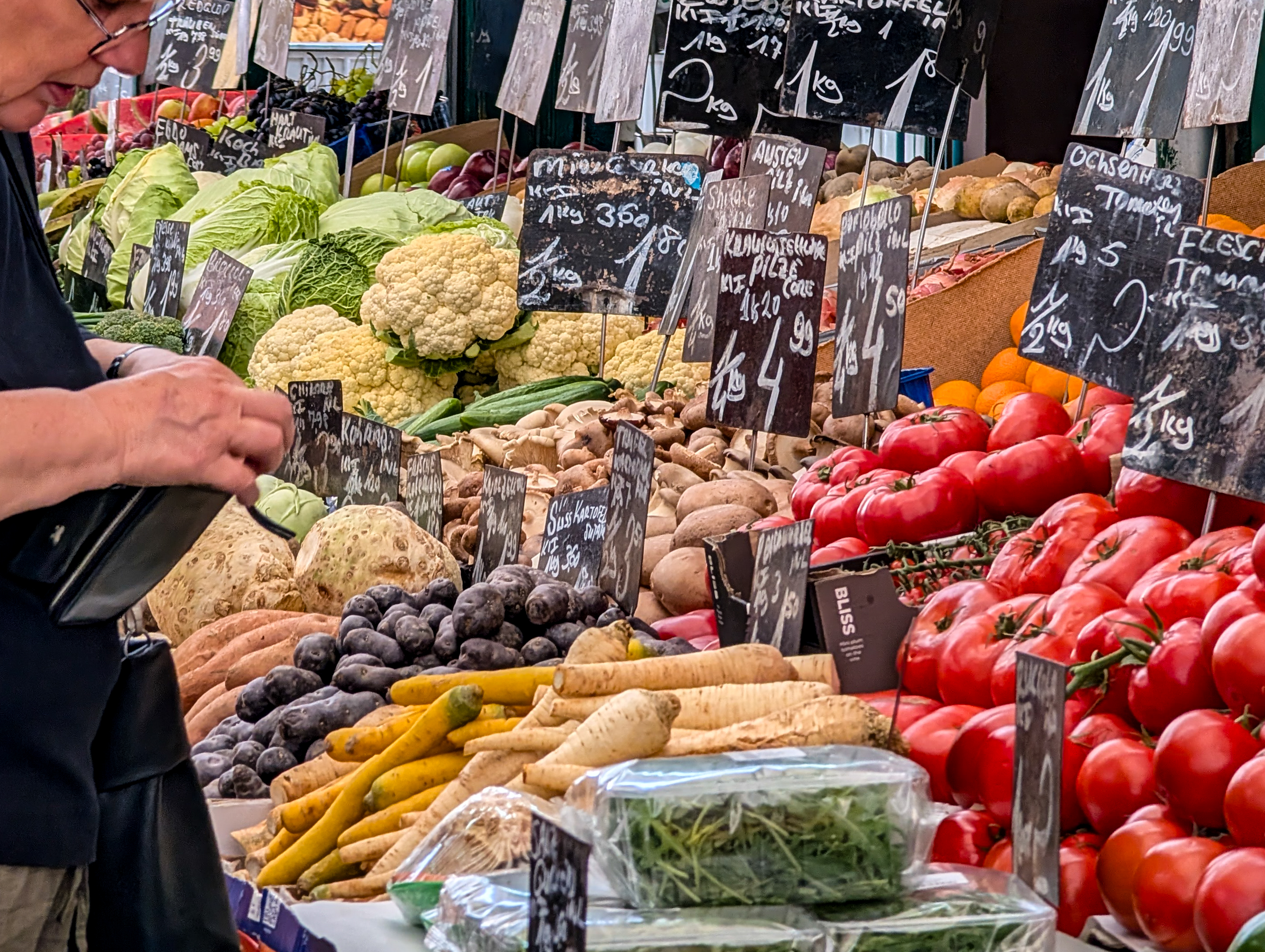 Frisches Gemüse und handgeschriebene Preisschilder werden an einem Marktstand ausgestellt | Quelle: Getty Images