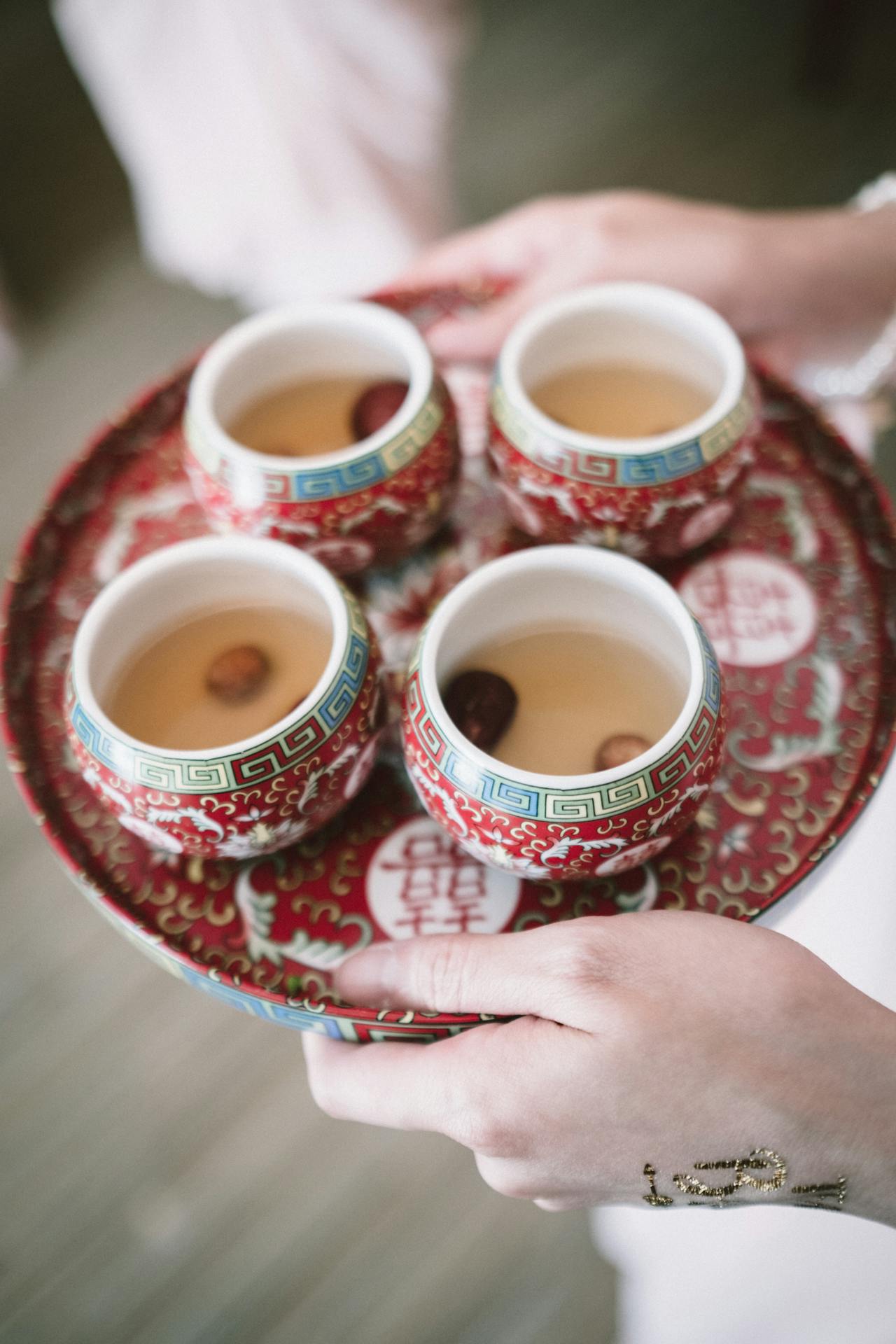 Eine Frau hält ein Tablett mit Teetassen | Quelle: Pexels