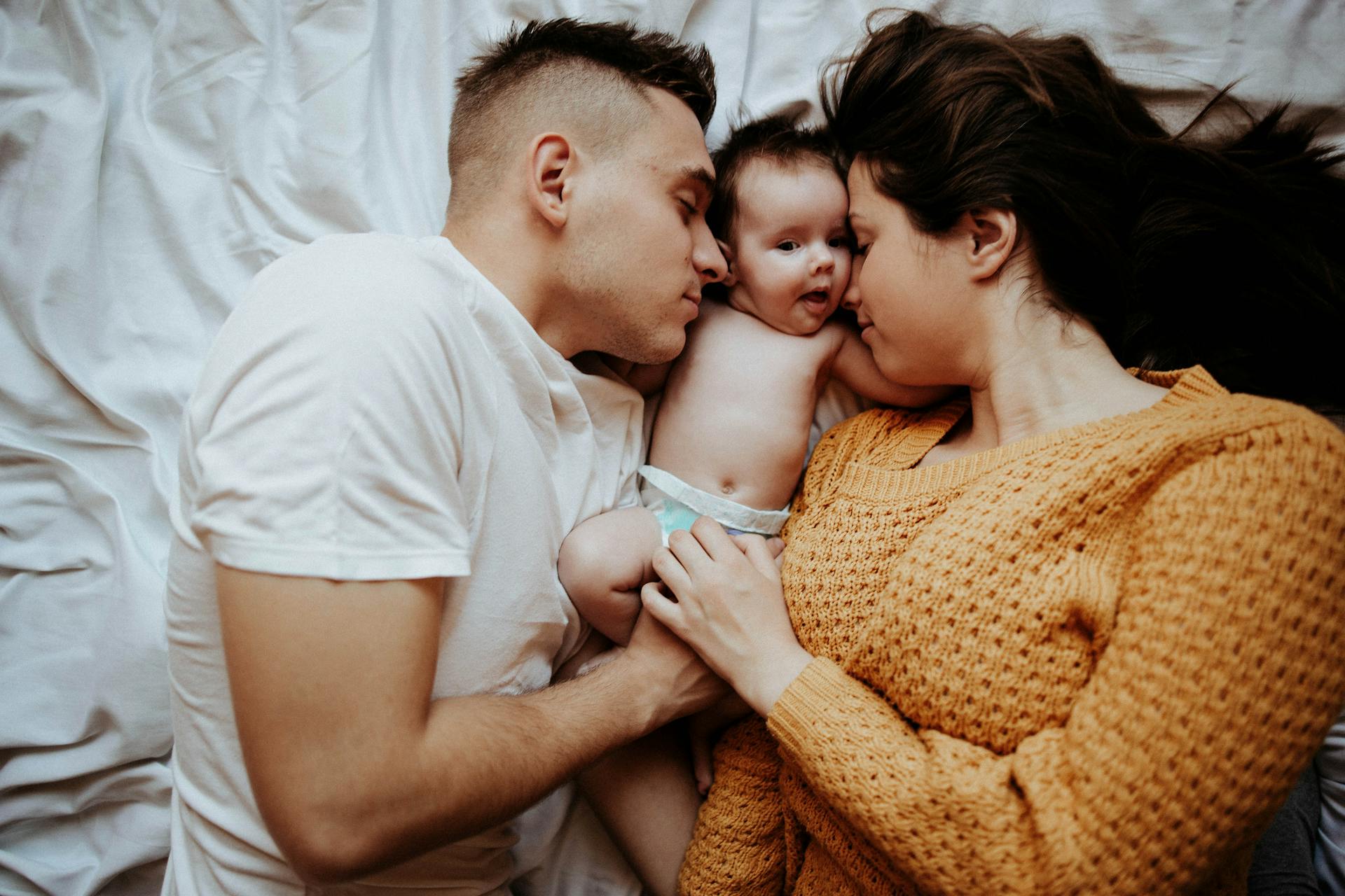 Ein Paar im Bett mit einem Baby | Quelle: Pexels