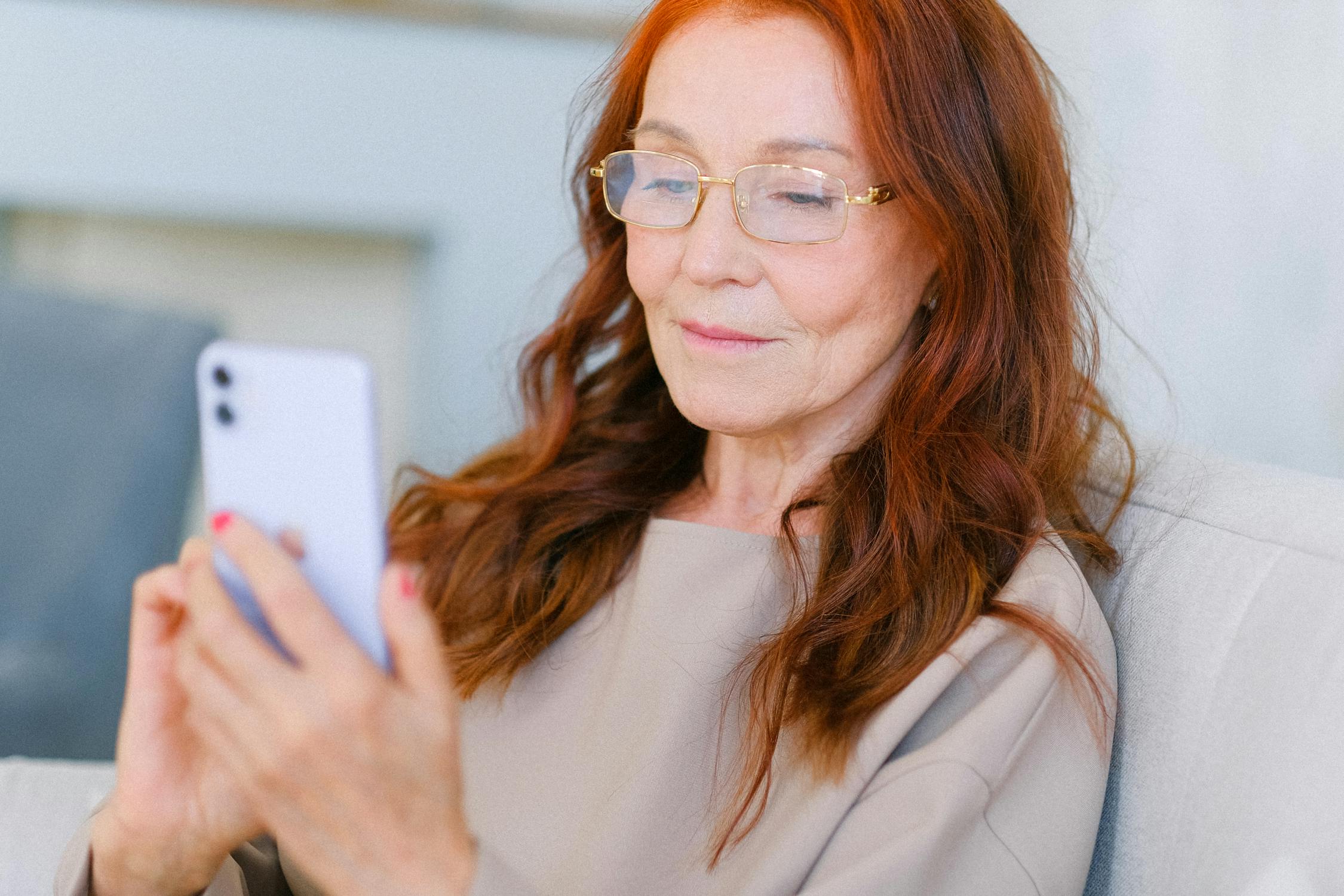 Eine reife Frau schaut auf ihr Telefon | Quelle: Pexels