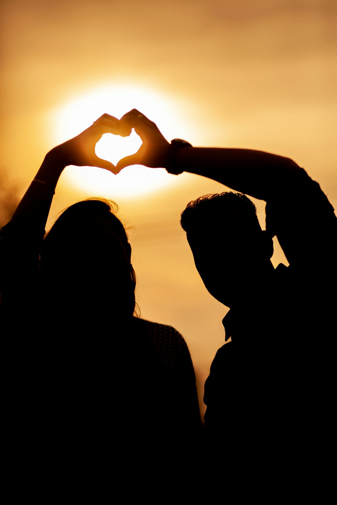 Silhouette eines Paares, das eine Hand-Herz-Geste macht | Quelle: Pexels
