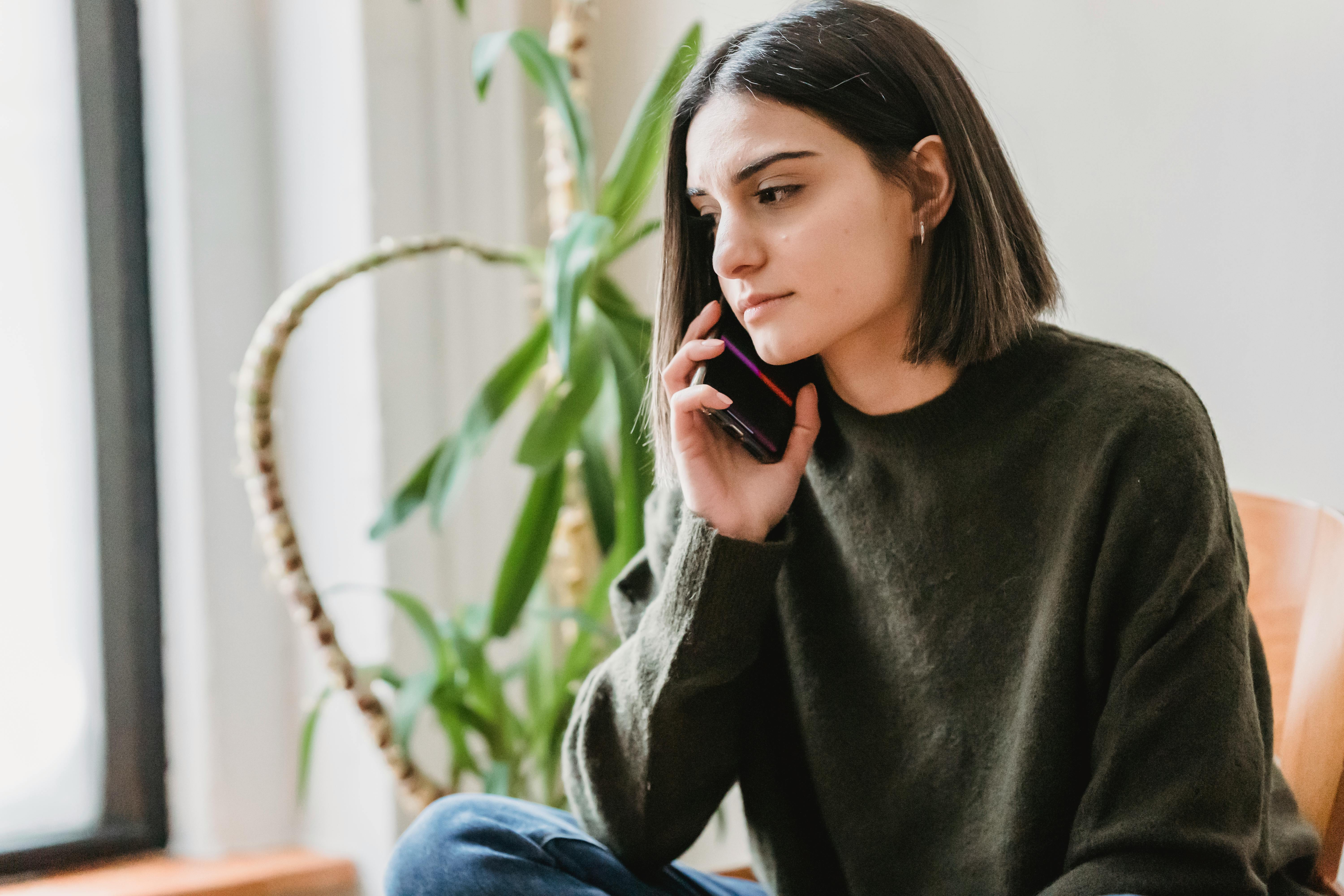 Eine streng dreinblickende Frau an ihrem Telefon | Quelle: Pexels