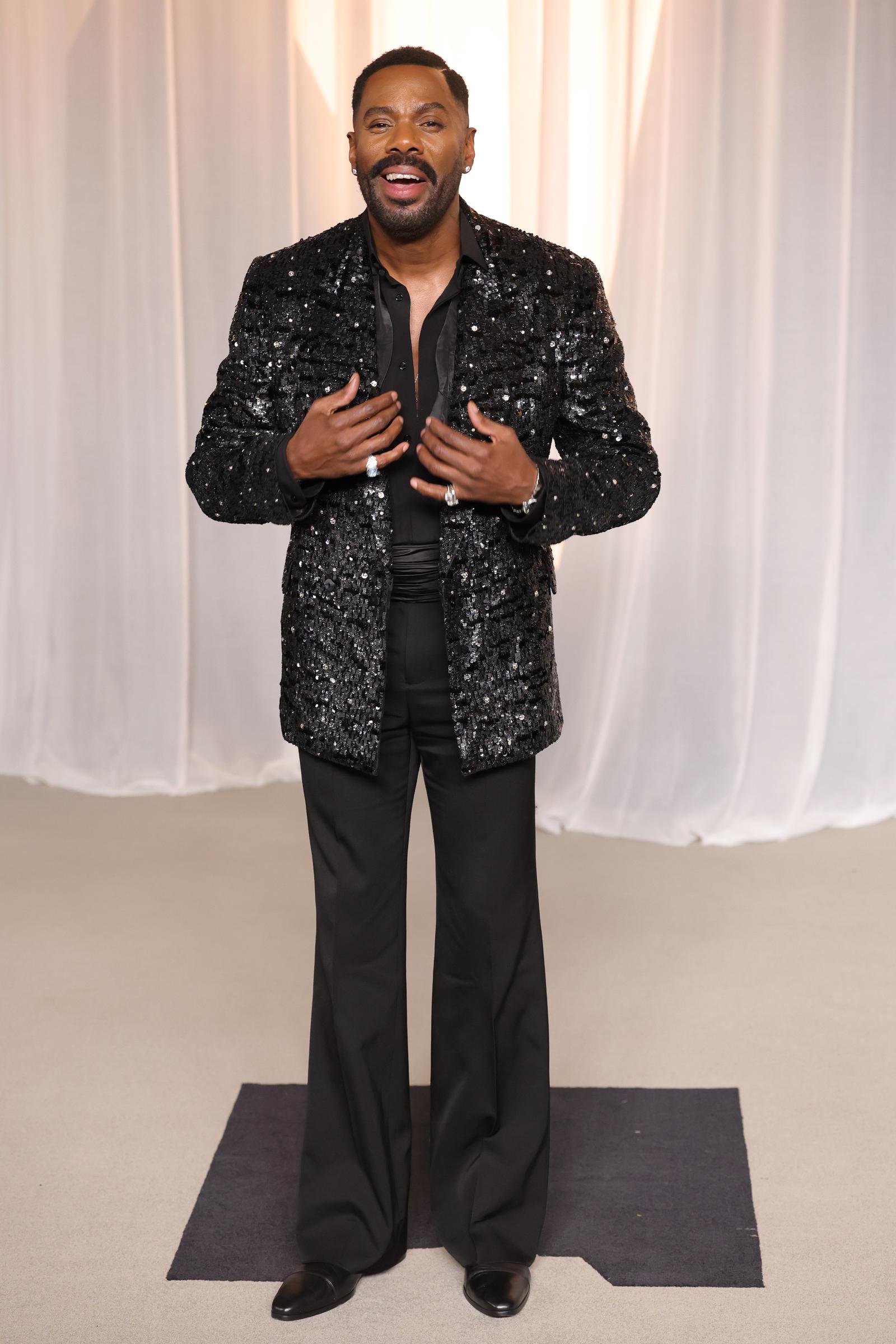 Colman Domingo zieht alle Blicke auf sich – in einem makellos geschneiderten schwarzen Outfit, dessen Herzstück eine funkelnde Paillettenjacke ist, dazu eine lässige Hose mit weitem Bein und glitzernde Statement-Ringe. Mit tief geöffnetem Kragen und einem strahlenden Lächeln verbindet der Schauspieler elegante Raffinesse mit seinem typischen gewagten Flair, während er die Verleihung des Vantage Award feiert.