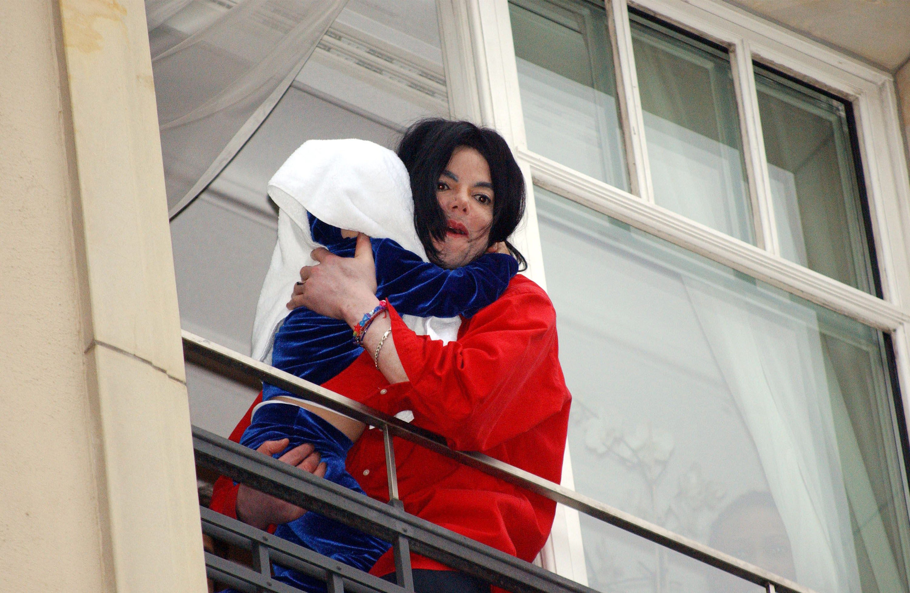 Michael Jackson mit einem seiner Kinder auf einem Balkon des Adlon Hotels in Berlin im Jahr 2002 | Quelle: Getty Images