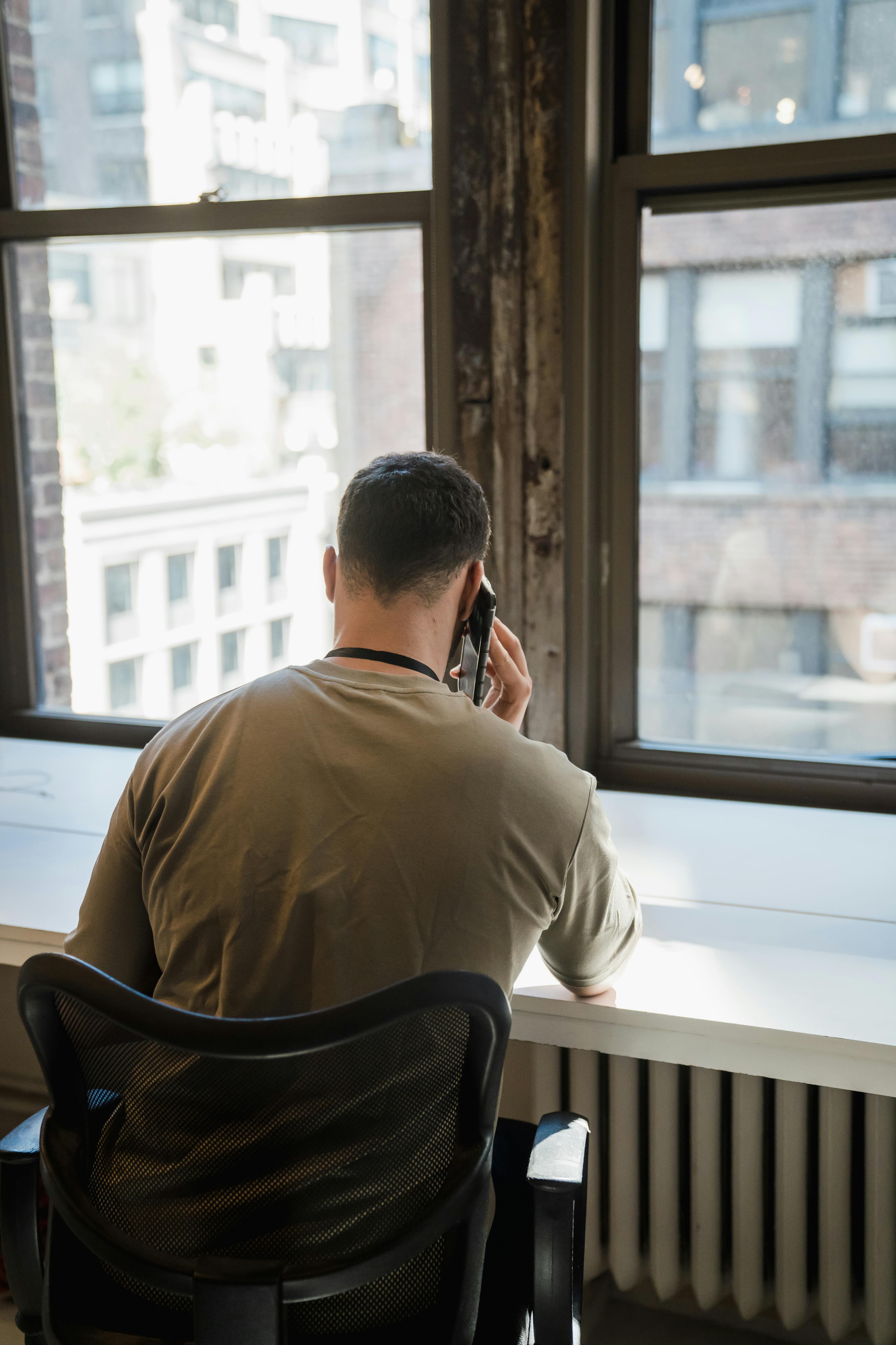 Um homem fala ao telefone de costas para a câmera | Fonte: Pexels