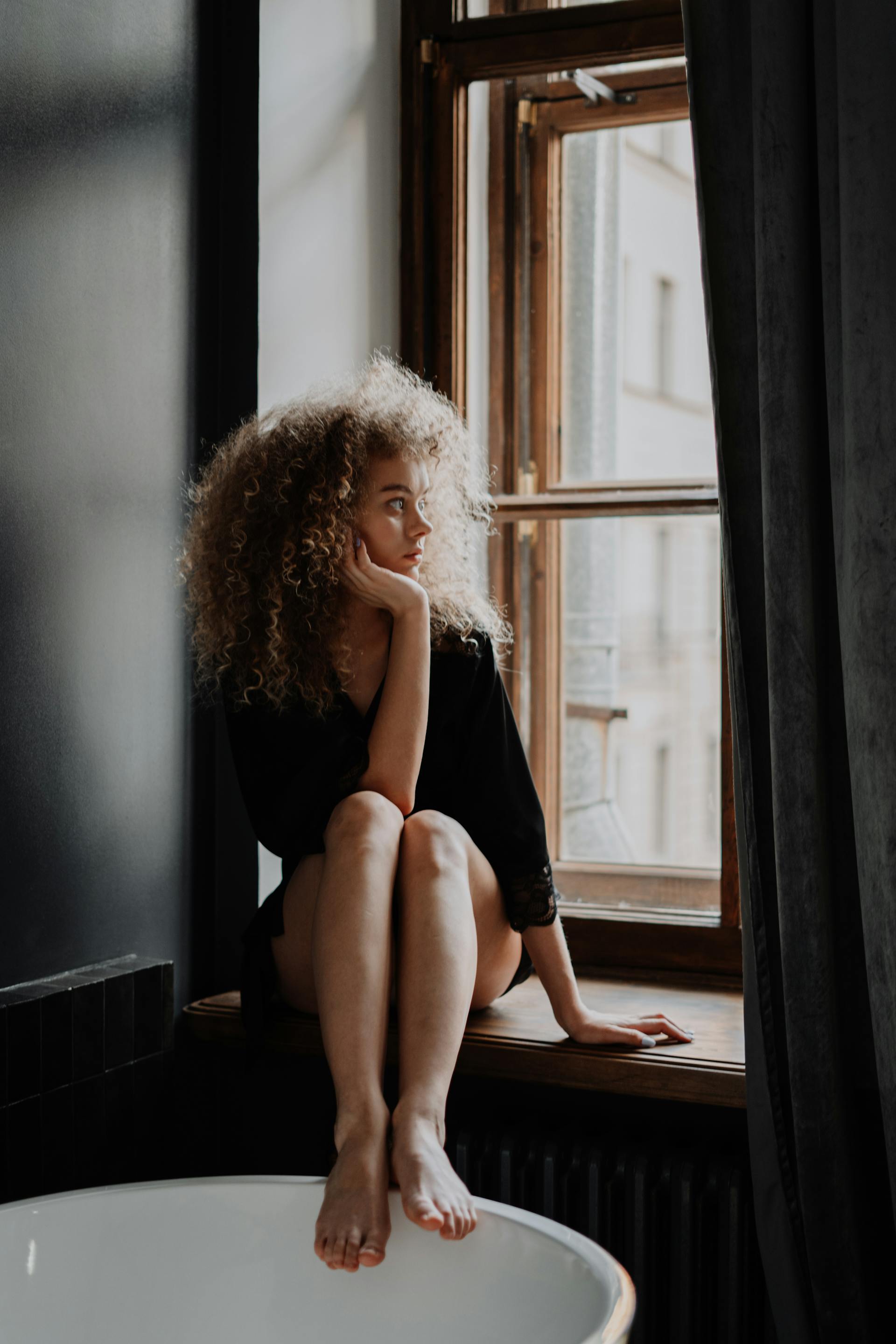 Eine Frau, die aus einem Fenster schaut | Quelle: Pexels