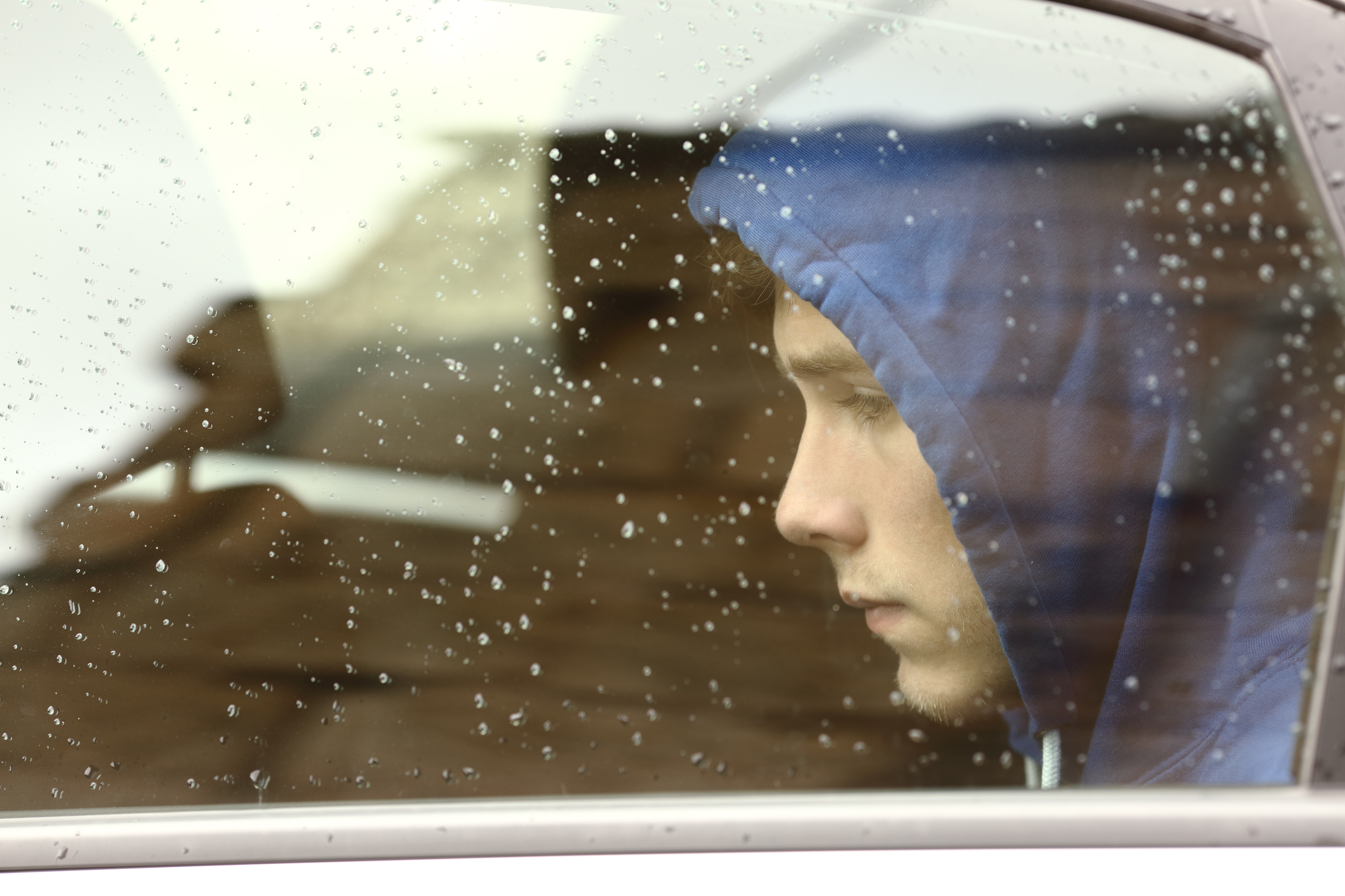 Trauriger Teenager, der durch das Autofenster schaut | Quelle: Shutterstock