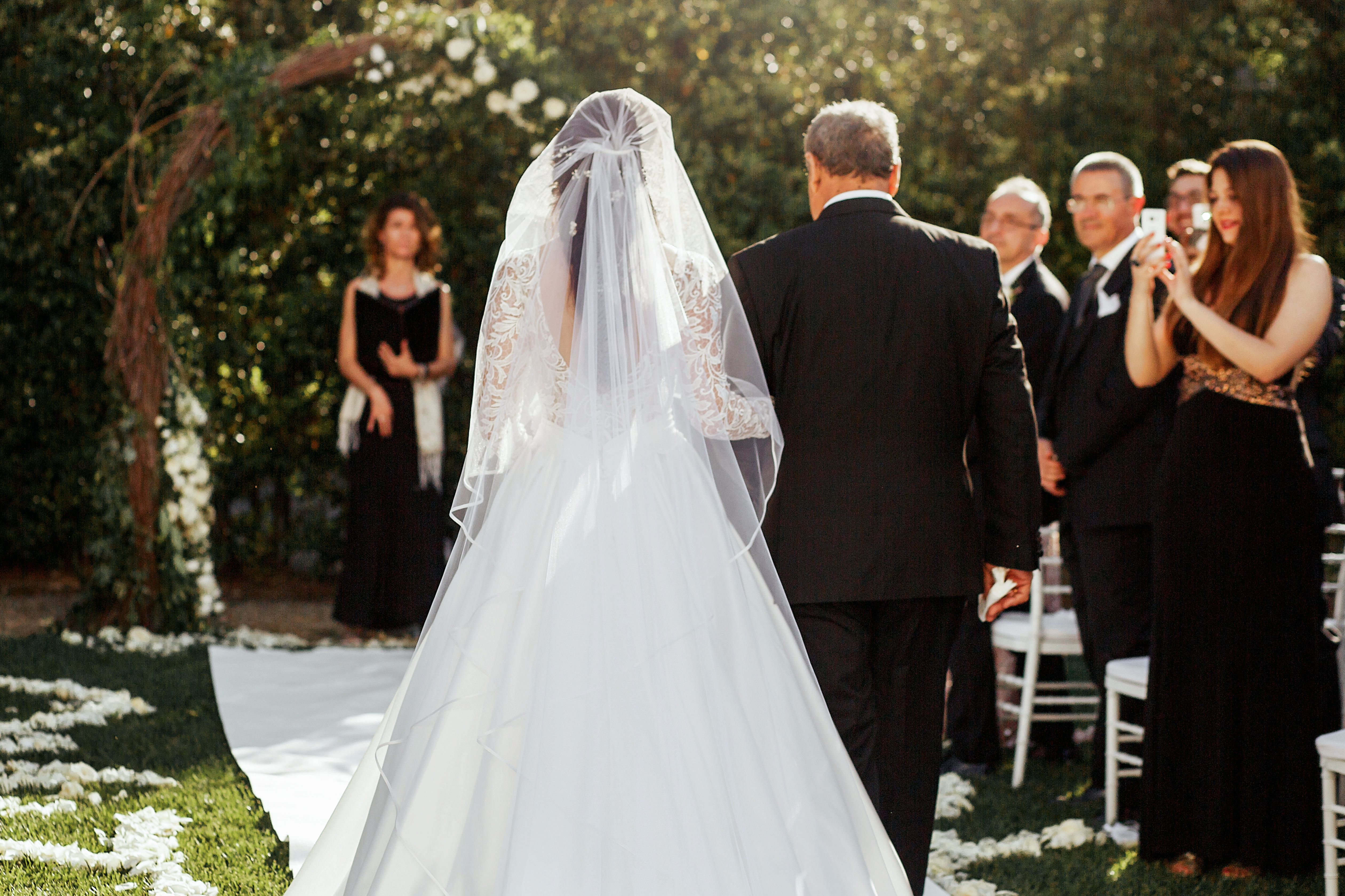 Vater, der seine Tochter an ihrem Hochzeitstag zum Altar führt | Quelle Shutterstock