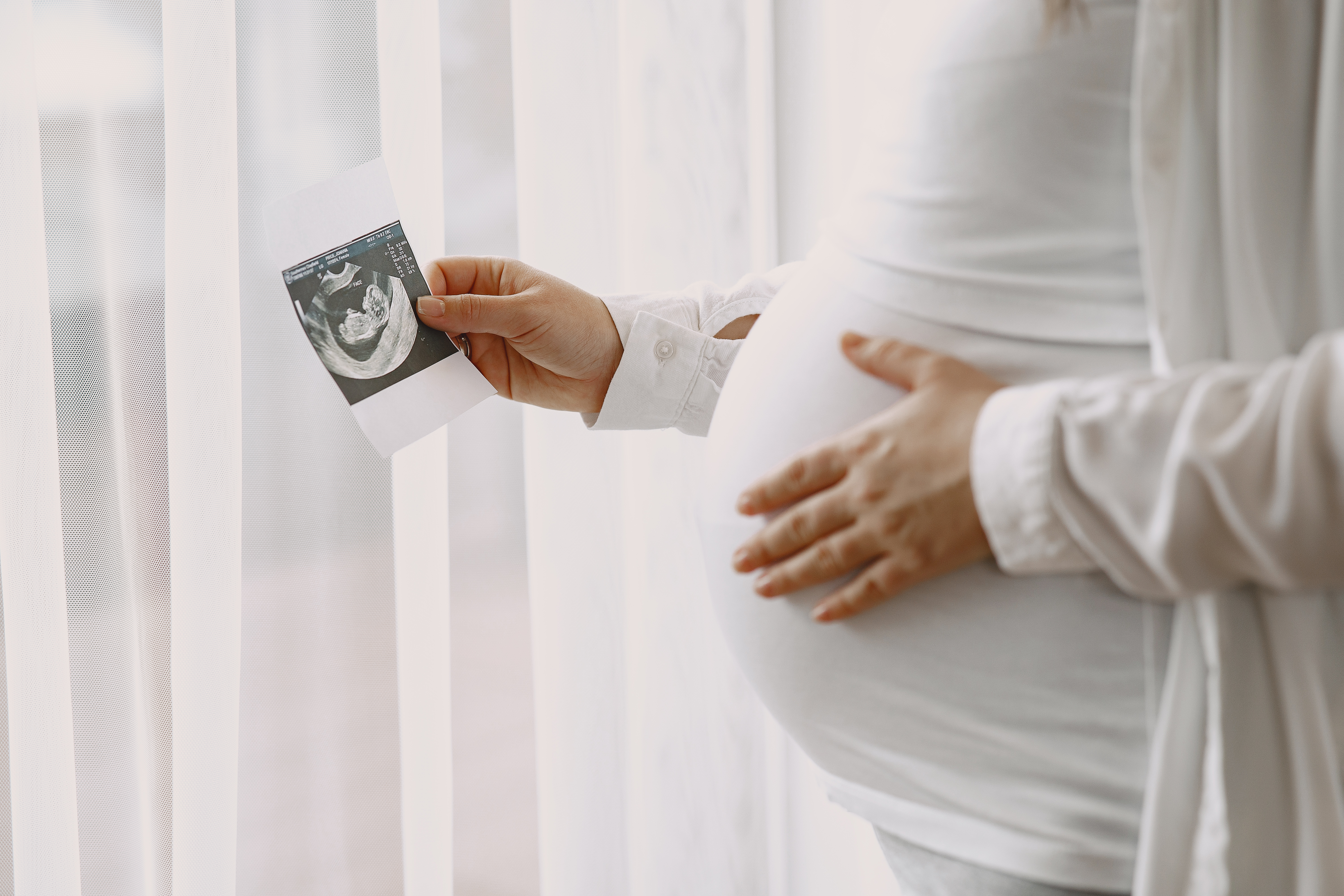 Eine schwangere Frau sieht sich ein Ultraschallbild ihres Babys an. Nur für Illustrationszwecke | Quelle: Freepik