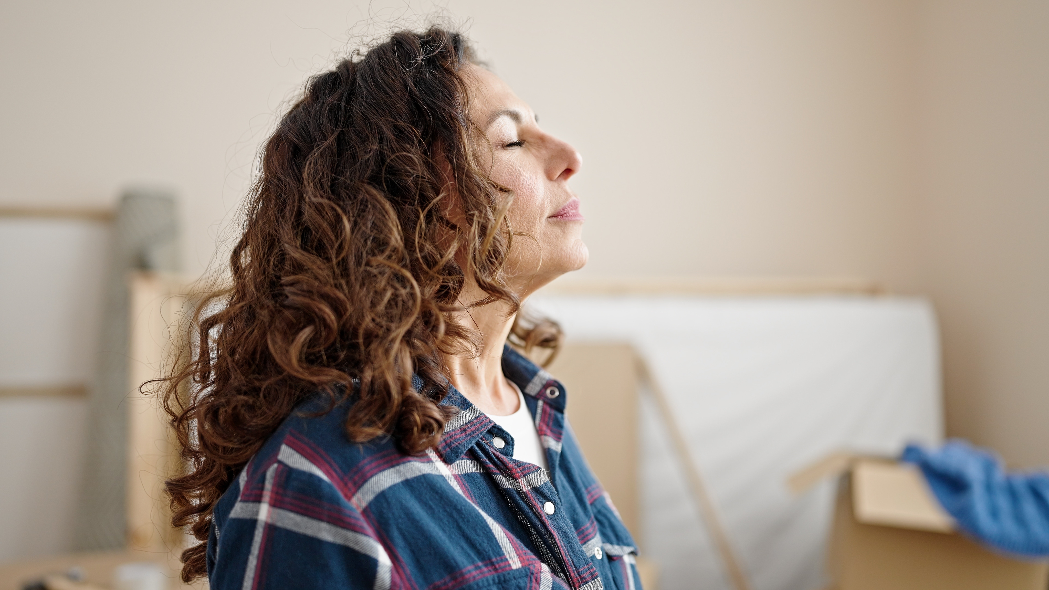 Frau atmet mit geschlossenen Augen | Quelle: Shutterstock