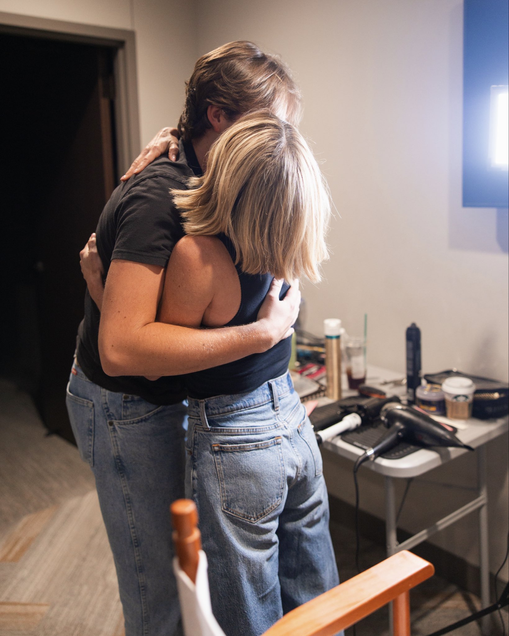 Candace Cameron Bure umarmt ihren Sohn Maksim Bure hinter den Kulissen ganz zärtlich und legt ihren Kopf an seine Schulter – das beide tragen passende schwarze Oberteile und hellblaue Jeans. | Quelle: X/candacecbure